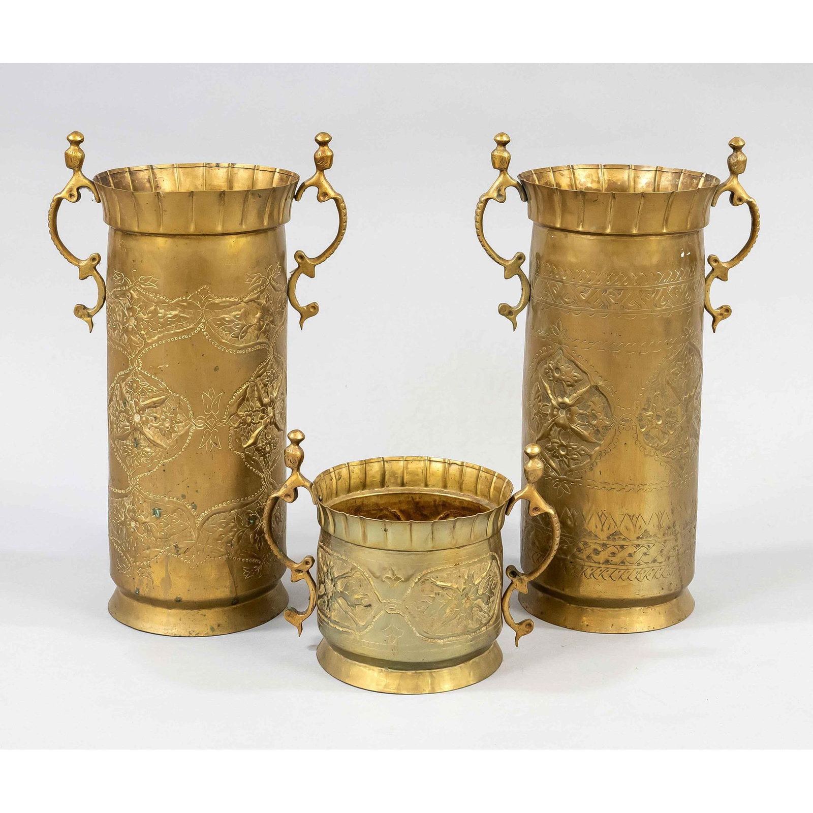 3 Brass containers, end of the 19t: 3 Brass containers, end of the 19th century, e.g. as umbrella stands or cachepots. The walls with chased decorations, curved handles, h. up to 55 cm.