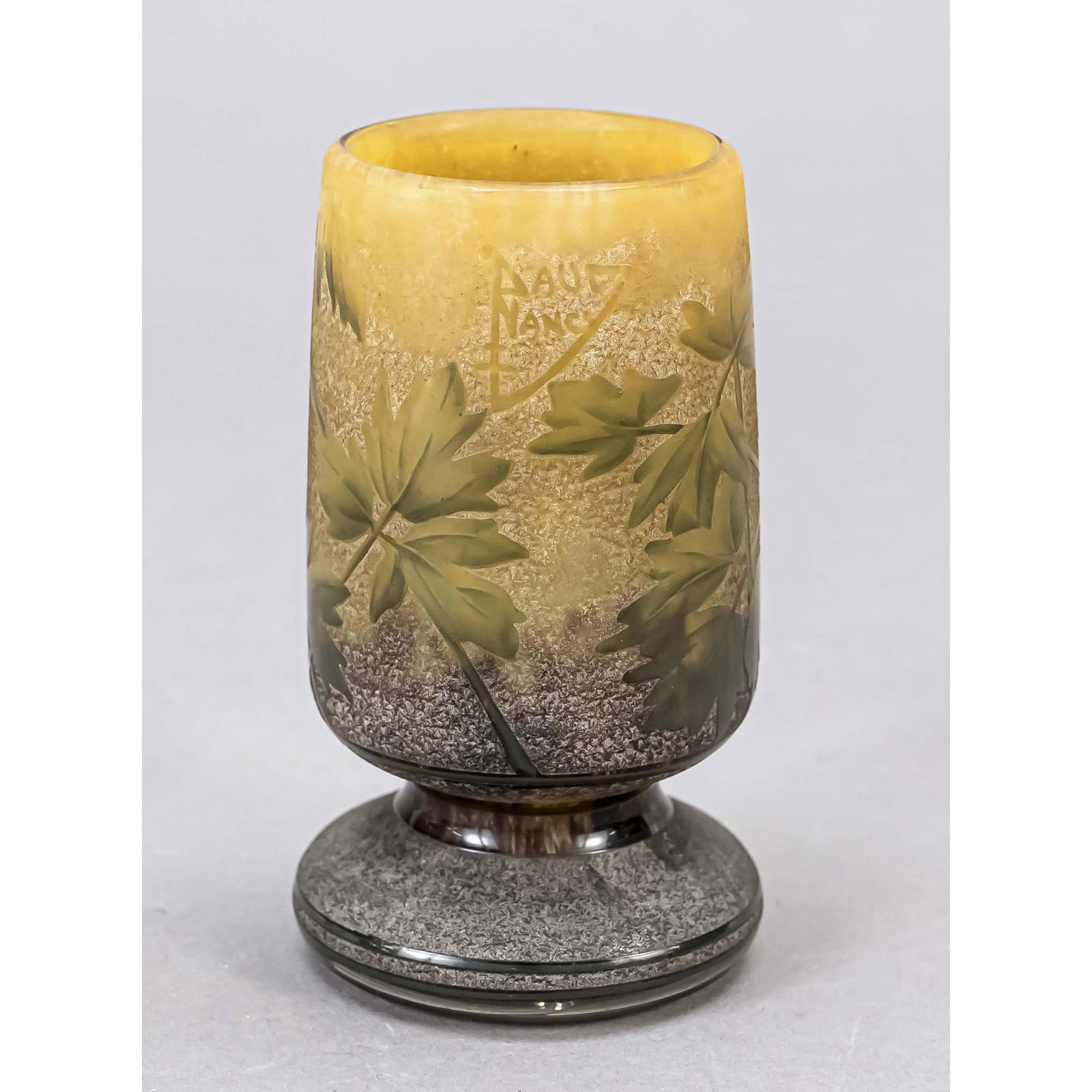 A footed vase, France, c. 1900, Daum: A footed vase, France, c. 1900, Daum, Nancy, round stand, short shaft, body with slightly tapering wall, clear, beige and brown glass, partly overlaid with etched floral decoration, signed, h. 11.5 cm