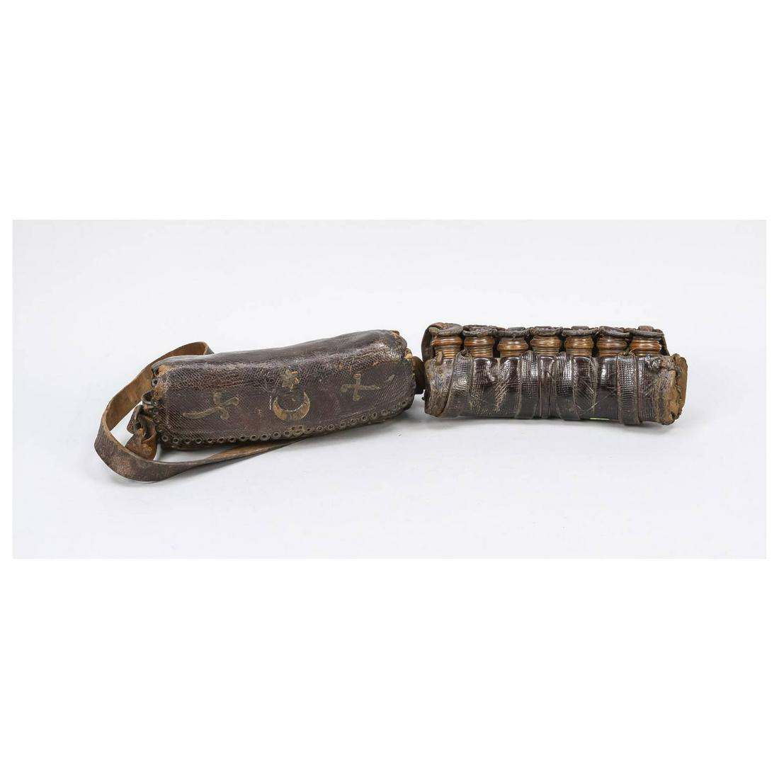 2 ammunition bags, Ottoman, 19th c: 2 ammunition bags, Ottoman, 19th century, bags made of dark brown embossed leather, 1 x with belt. Each with 7 turned containers for gunpowder. One of them is decorated with a star over a crescent moo