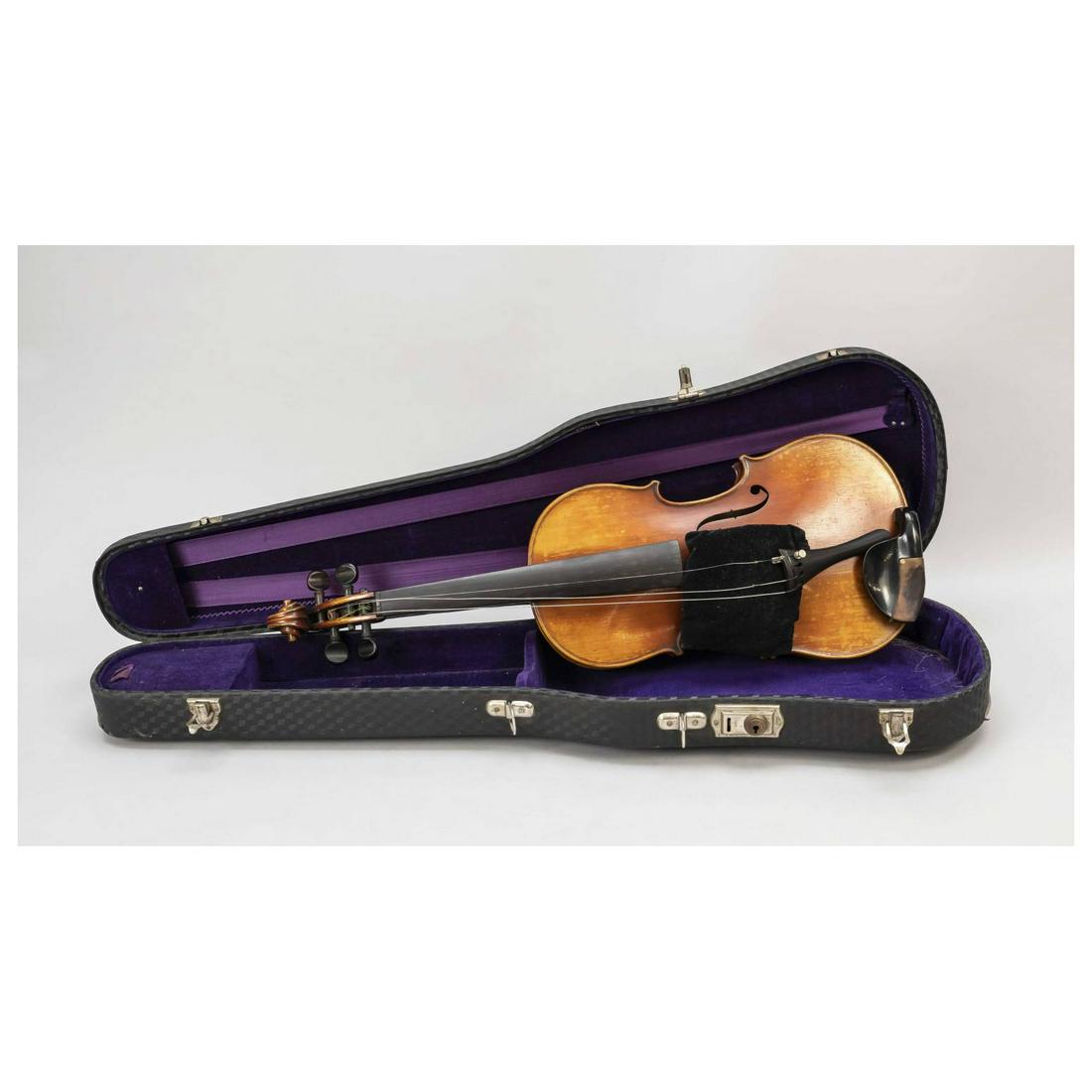 Violin in violin case, around 1900: Violin in violin case, around 1900. Inscribed on a label inside the body ''Antonius Stradivarius Cremonensis Fecibat Anno 1719'', l. 60 cm. Black violin case with textured surface, lined with purple v