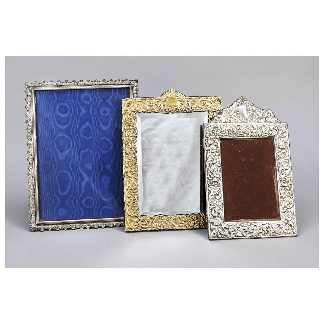 Two photo stand frames, 20th c., silv: Two photo stand frames, 20th c., silver hallmarked or tested, each with floral decoration, clear size 14.5 x 10 and 23 x 17 cm, overall dimensions 25 x 15.5 and 27 x 20.5 cm, plus table mirror, 20th c