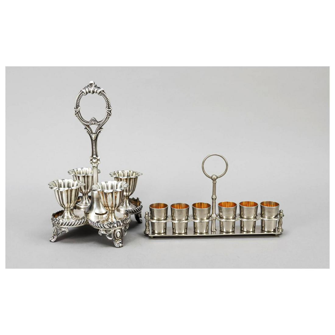 Two sets, 20th c., plated, 1x egg cup: Two sets, 20th c., plated, 1x egg cup set, 4-pass form on 4 decorated feet, central handle, complete with 4 egg cups, spoons missing, h. 27,5 cm, 1x liquor cup set, rectangular stand on 4 feet, centra