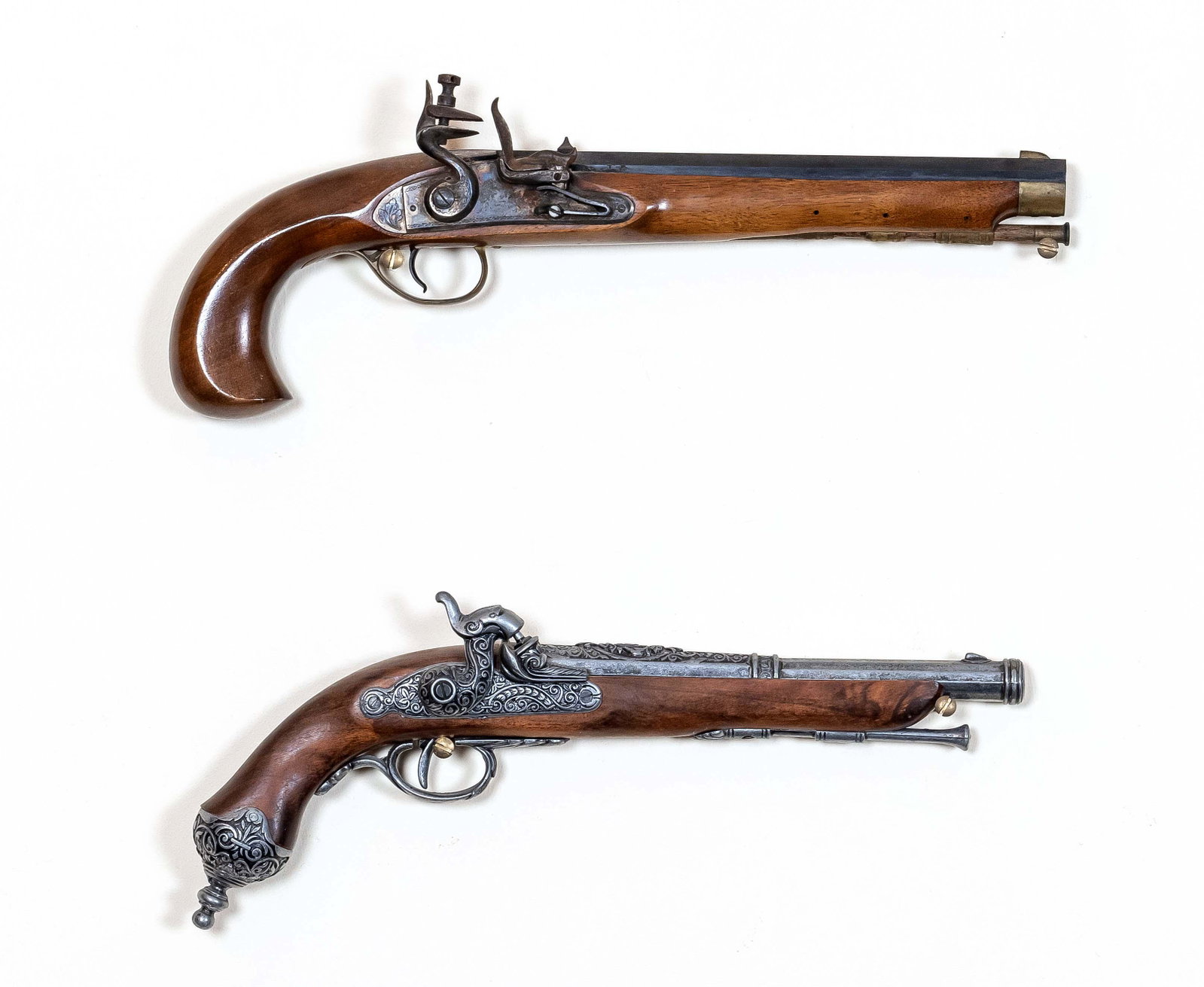 Two decorative pistols, 20th centu: Two decorative pistols, 20th century, flintlock and percussion, walnut, iron, brass ornaments, the black- barreled pistol can be fired , L. 40 and 37 cm . The preview of the inventory auction takes pl