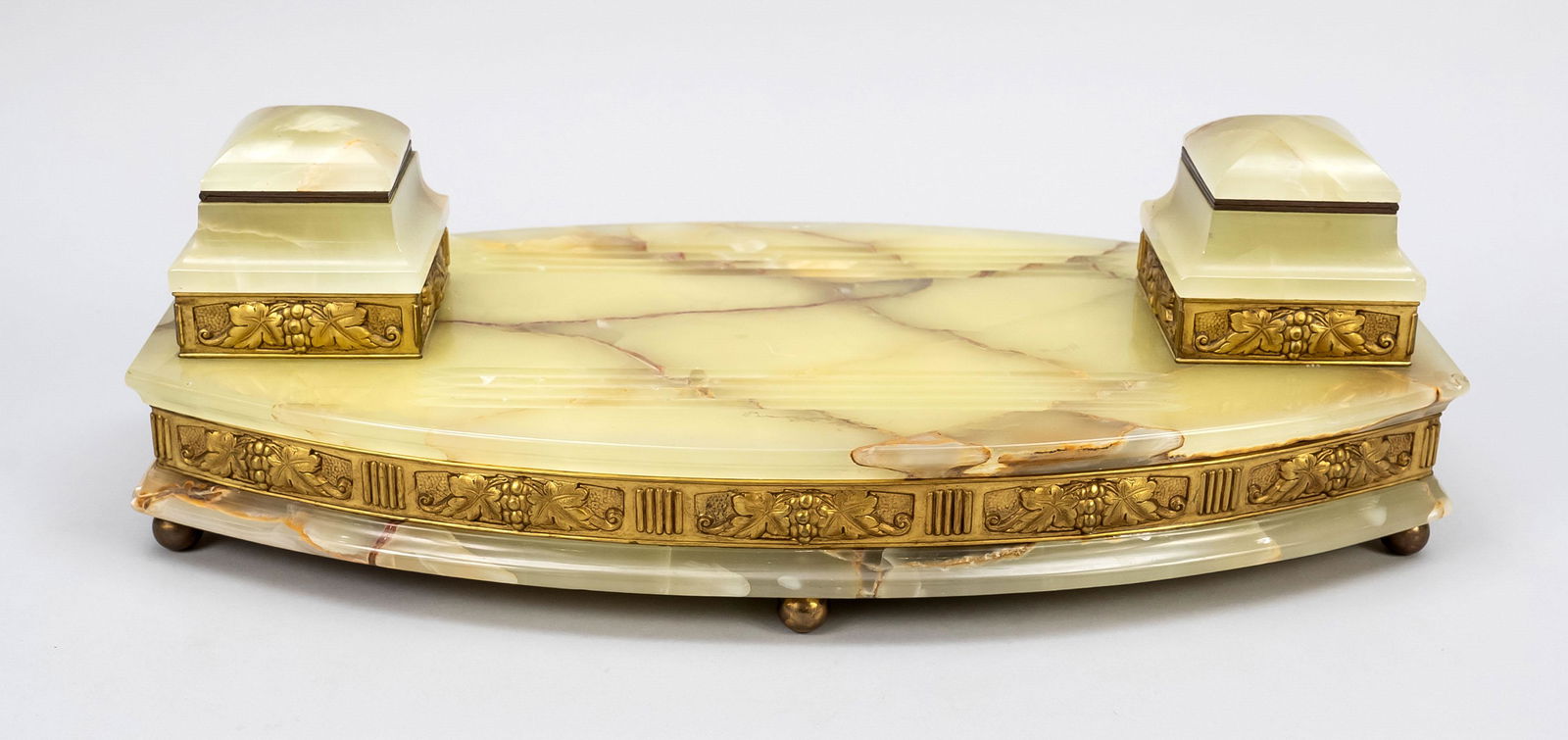 Desk attachment, late 19th c., onyx corpus on 6 ball feet, gilded relief bath with vine leaves: Desk attachment, late 19th c., onyx corpus on 6 ball feet, gilded relief bath with vine leaves ornament in iteration. Postament shaped inkwells with hinged lids, grooves for storing writing utensils,