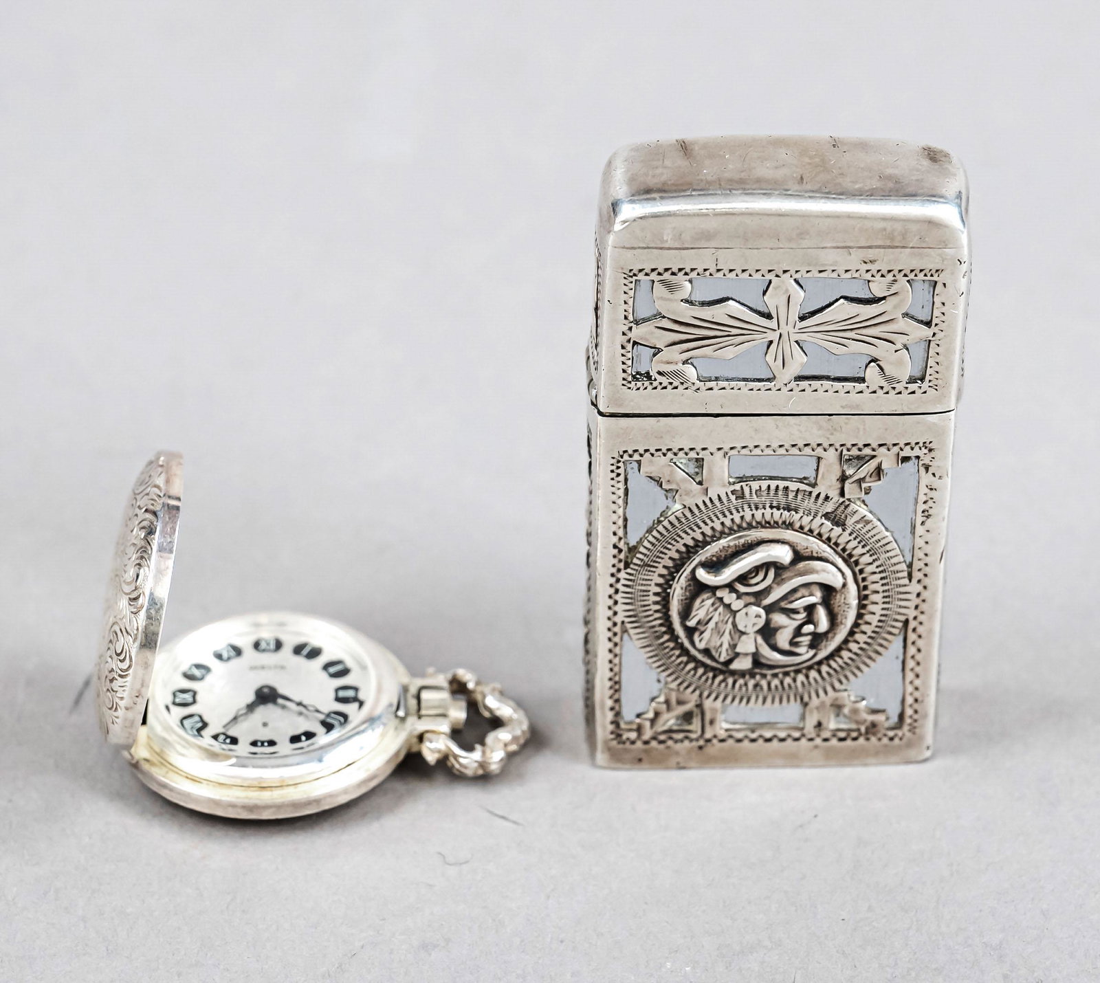 Lighter, Mexico, 20th century, sterling silver 925/000, with figural and ornamental decoration, l. 6: Lighter, Mexico, 20th century, sterling silver 925/000, with figural and ornamental decoration, l. 6 cm, together with ladies hanging watch, marked Welta, silver 800/000, lid with engraved decoration,