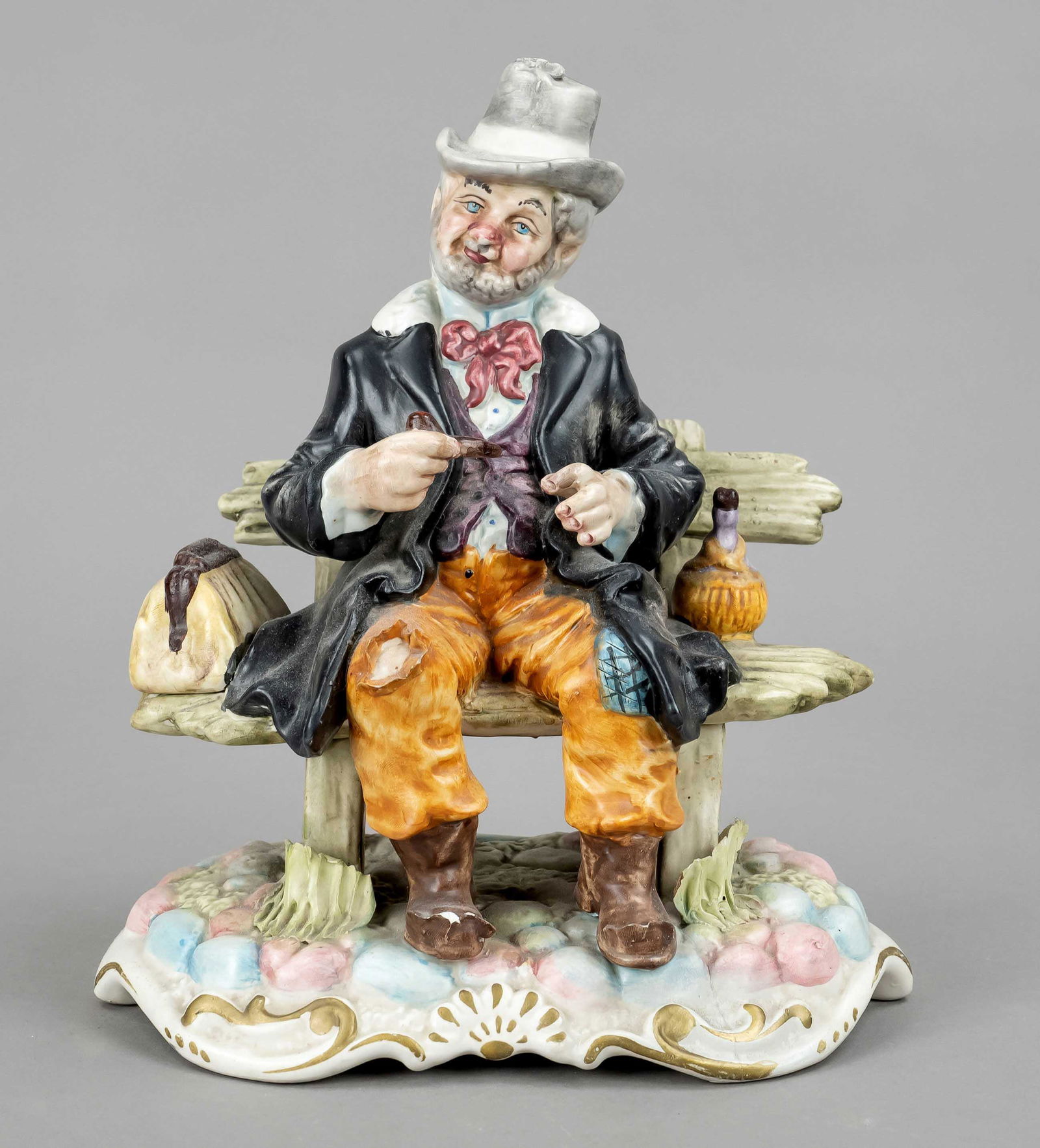 Sitting tramp with pepper on a: Sitting tramp with pepper on a bench, Capodimonte, end of 20th c., colored painted, slightly bumped, 29 x 23 x 15 cm