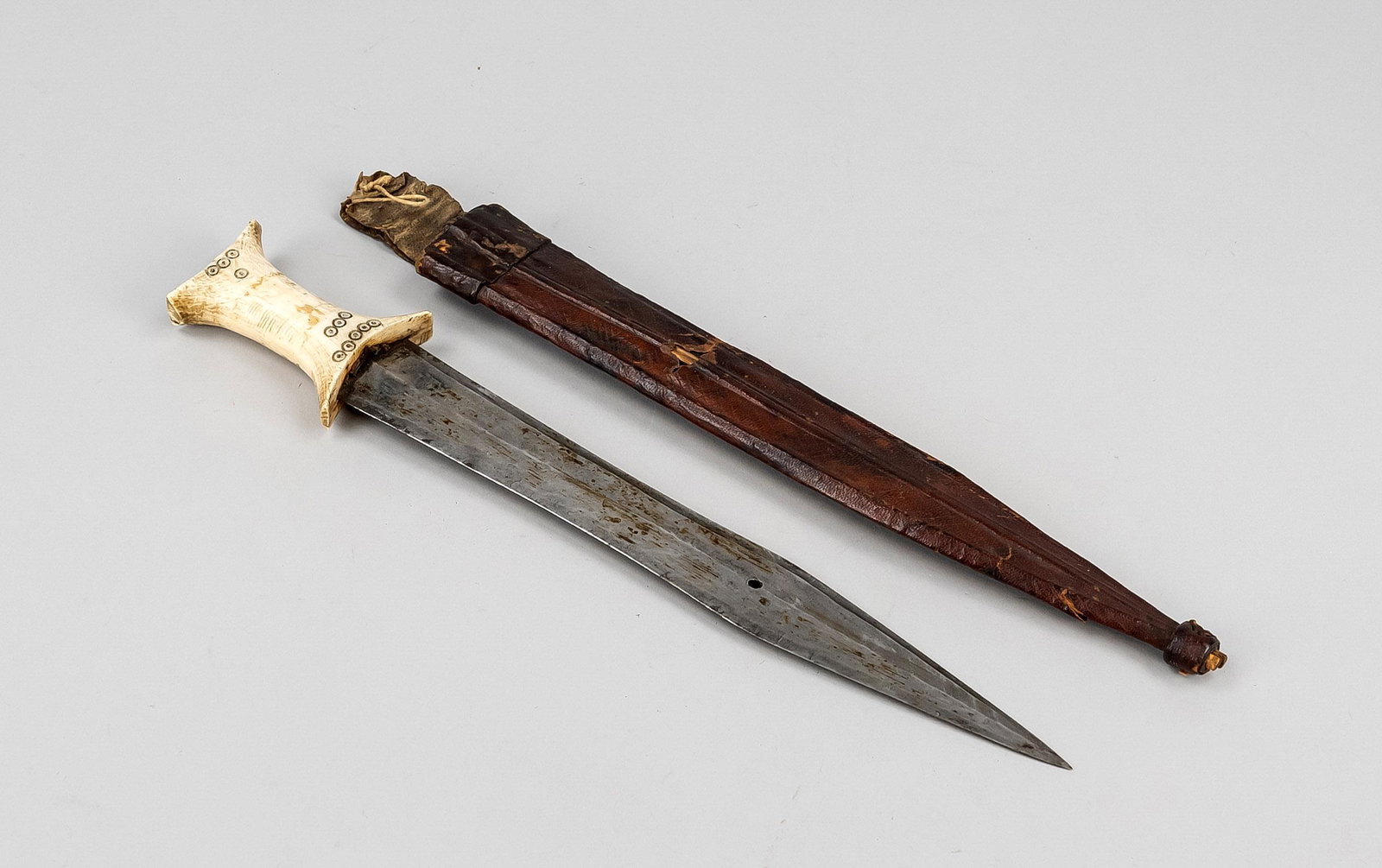 Knife with scabbard, probably: Knife with scabbard, probably Africa, probably 19th century, iron blade with central burr, leg handle with small blackened circular ornaments, leather scabbard, rubbed & bumped, l. 37 cm