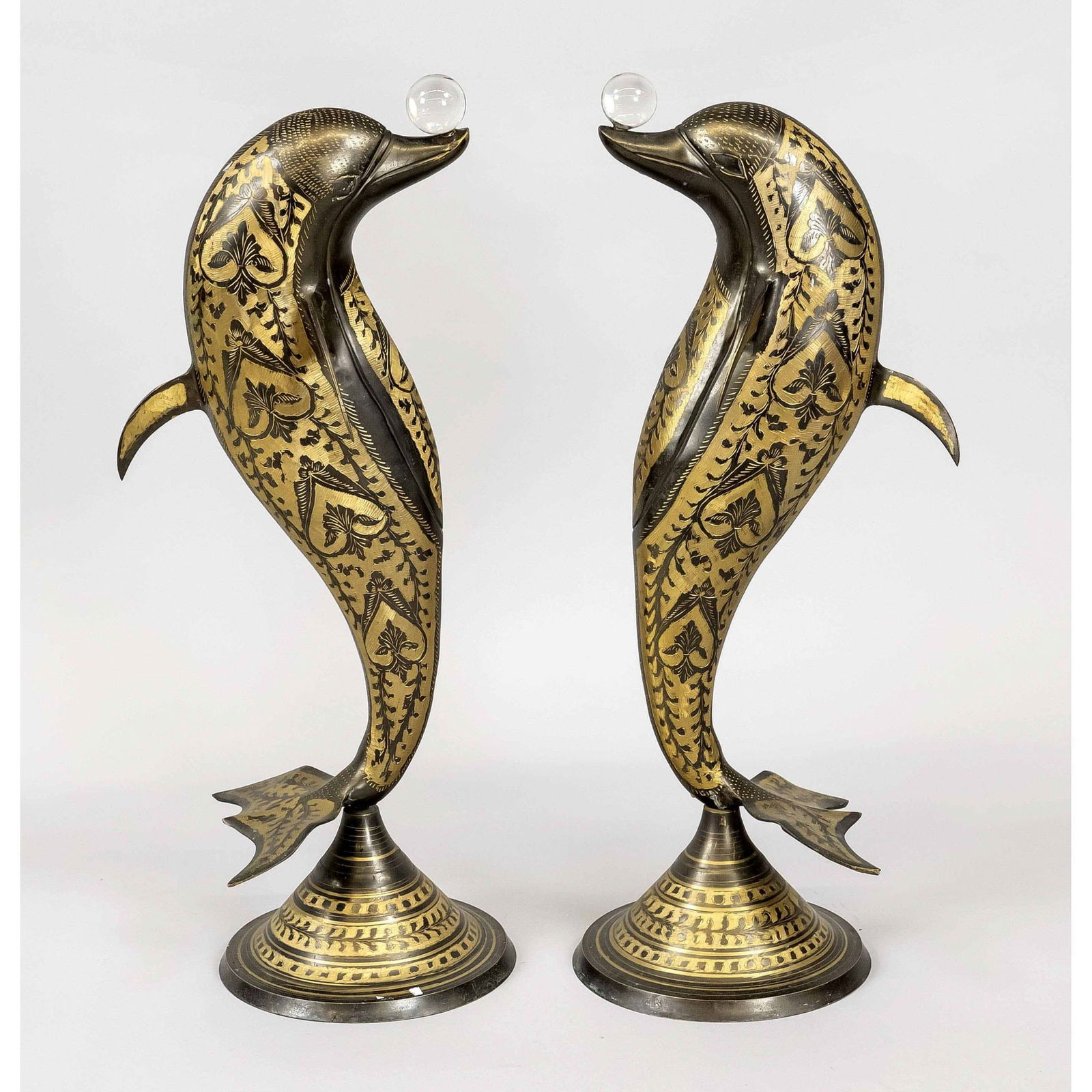 aar dolphins, 20th c., metal with: aar dolphins, 20th c., metal with cut/milled decoration. Standing on round ornamented base and balancing a glass ball on its snout. Slightly rubbed, h. 58 cm