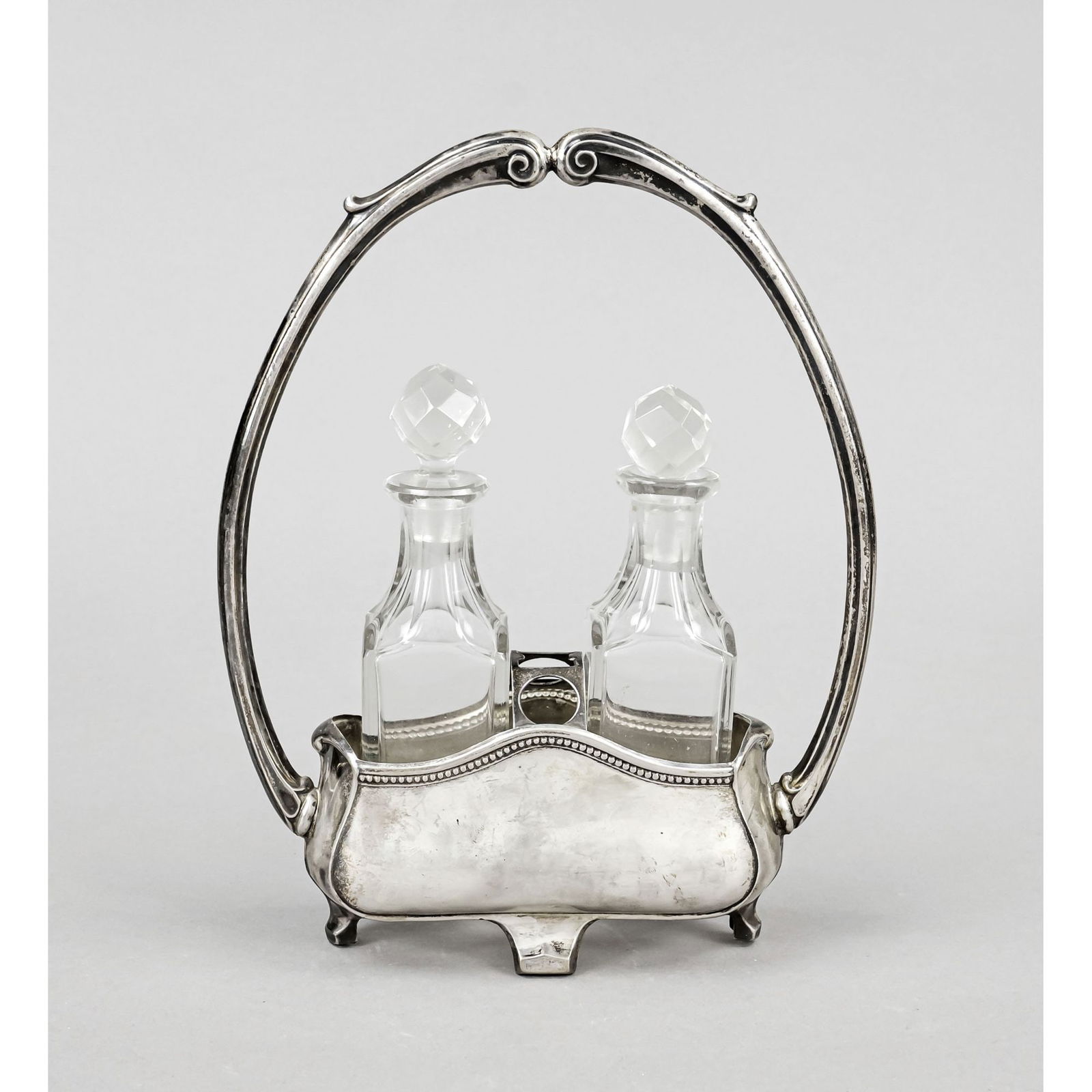 Cruet, Italy, 20th century, silver 800/: Cruet, Italy, 20th century, silver 800/000, on 4 feet, curved shape, overlapping, rigid handle, h. 23.5 cm, approx. 103 g, complete with 2 flasks, clear glass, h. 15 cm