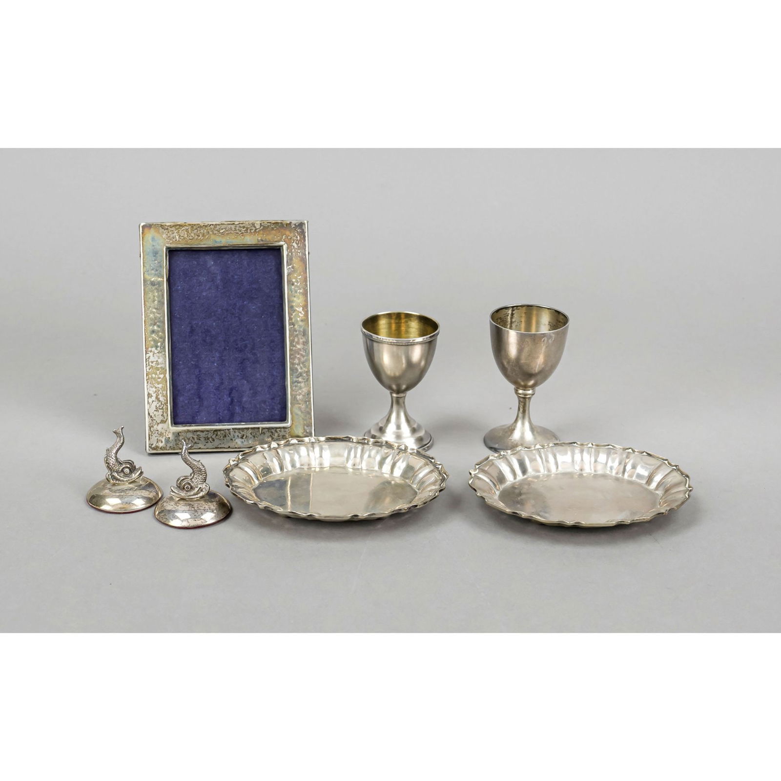 Mixed lot of seven small items, 20th: Mixed lot of seven small items, 20th century, various makers, silver of varying fineness, 2 egg cups, 2 oval bowls, rectangular photo stand frame and 2 dolphins as place card holders (?), l. up to 12