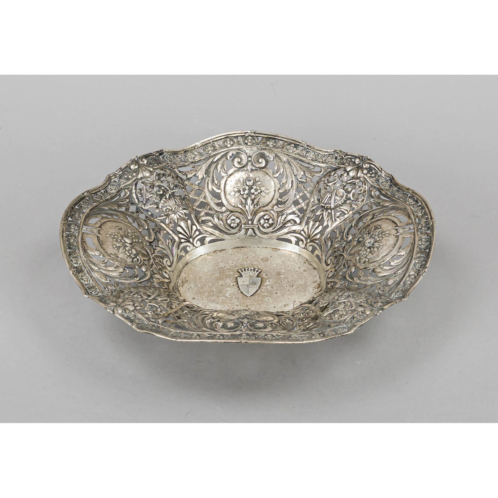Oval openwork bowl, c. 1900, hallmar: Oval openwork bowl, c. 1900, hallmarked silver, oval stand, curved body, richly pierced wall with floral and ornamental relief decoration, mirror with applied coat of arms decoration with baronial cro