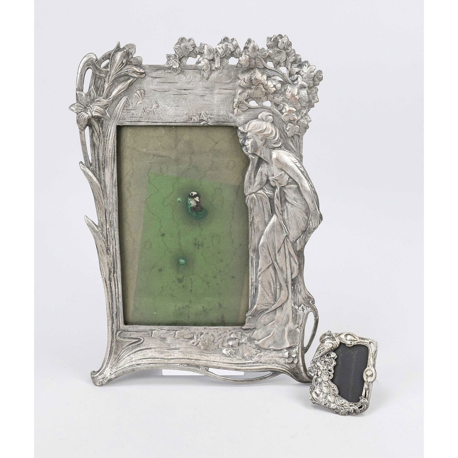 2 Art Nouveau picture frames, earl: 2 Art Nouveau picture frames, early 20th century, white metal. The larger frame with a seated lady between leaves, tendrils and typical Art Nouveau decoration. The small one with a peacock. Stand on t
