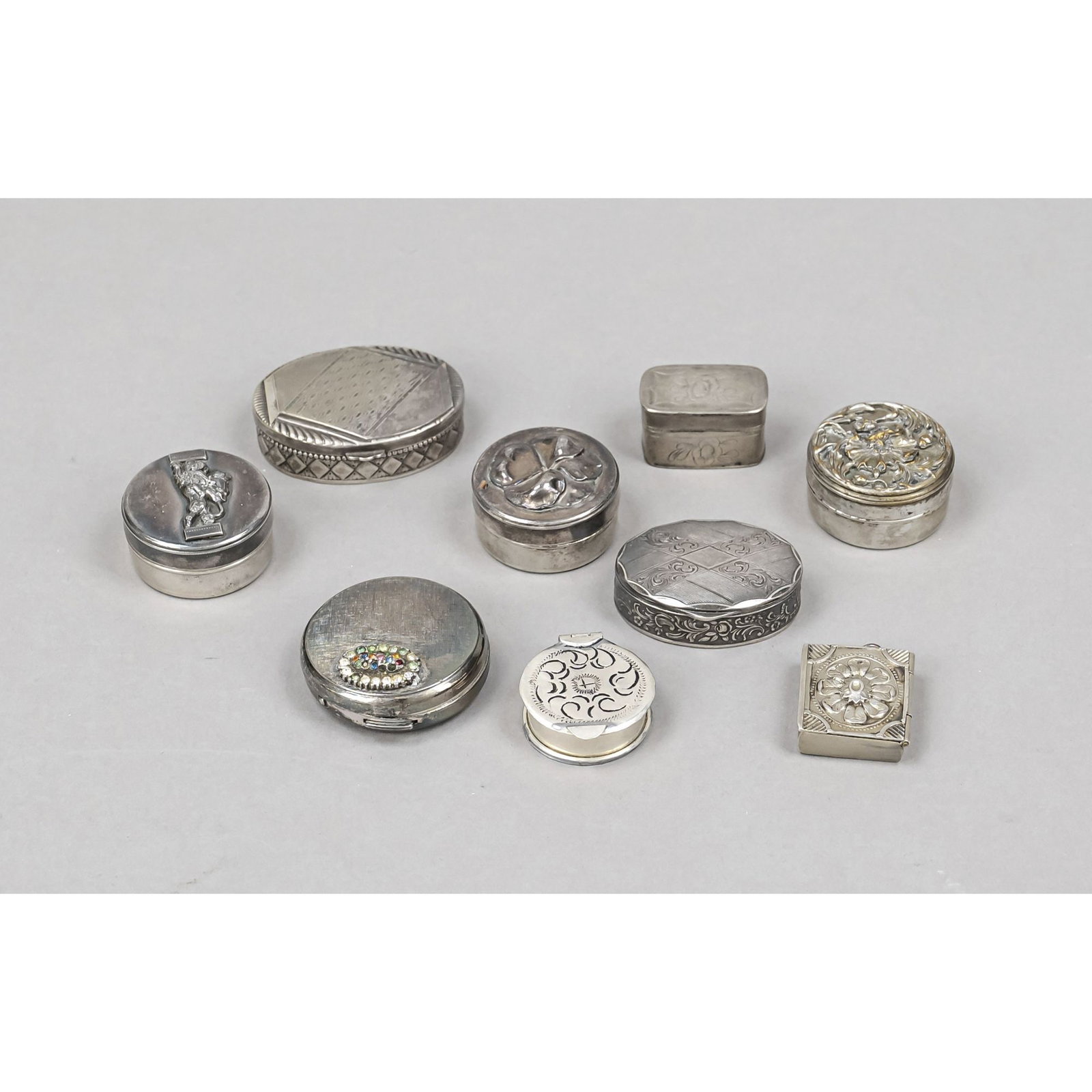 Nine pillboxes, 20th century, silve: Nine pillboxes, 20th century, silver and plated, various shapes and sizes, some with relief decoration, 1x with glass stone trim, Ø up to 4.5 cm, l. up to 5.5 cm