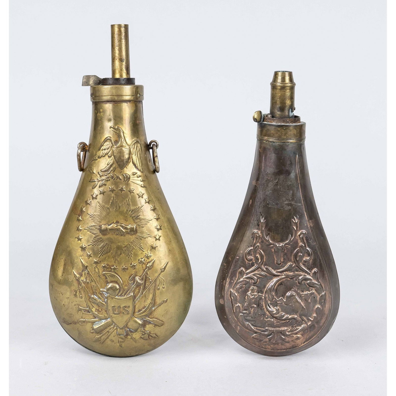 2 powder flasks, 19th century, sheet: 2 powder flasks, 19th century, sheet copper and brass. 1 x USA patriotic with eagle and military insignia, 1 x hunting with deer head and hunting scene, slightly chipped, l. up to 22 cm.