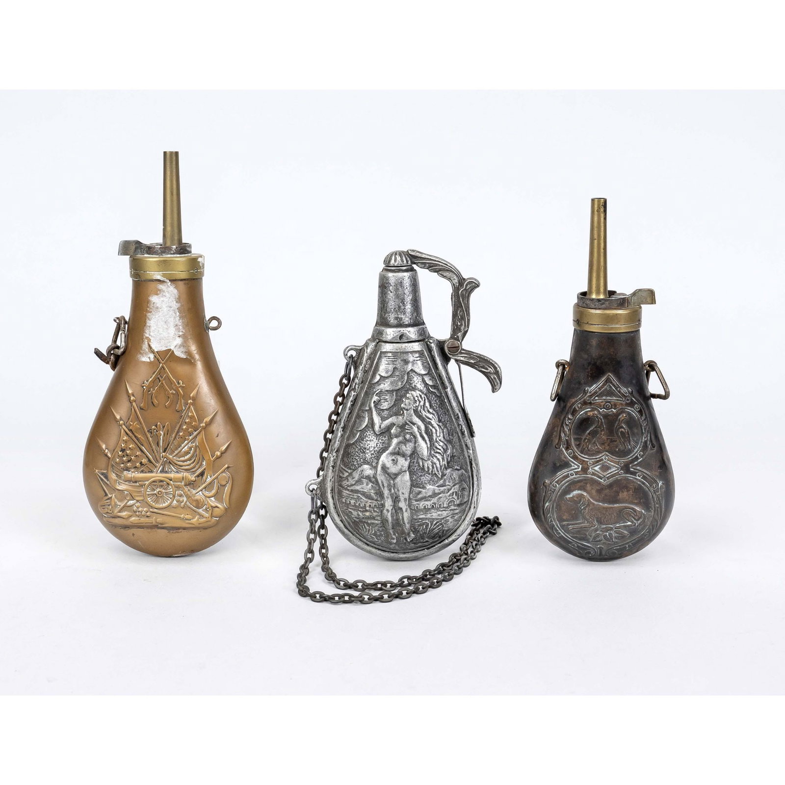 3 powder flasks for black powder, 19t: 3 powder flasks for black powder, 19th/20th century Two sheet copper and brass, one with hunting motifs, one with US patriotic motifs (remnants of paper glue on neck). One zinc casting, 20th century w