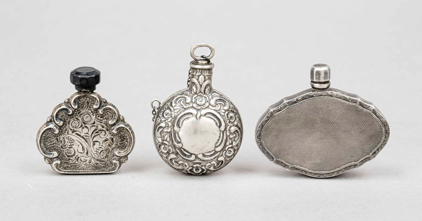 Three small flasks, 20th century, silv: Three small flasks, 20th century, silver tested, various shapes and sizes, with relief or engraved decoration, l. to 6.5 cm. Gross total weight approx. 70 g