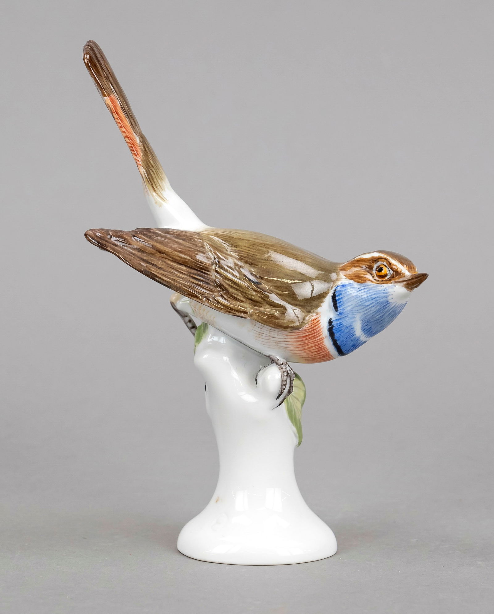 Bluethroat, Meissen, c. 1980.1st choic: Bluethroat, Meissen, c. 1980.1st choice, model no. 77271, designed by Erich Oehme in 1913, figurative depiction of a bluethroat on a tree stump with foliage, polychrome painted, h. 15 cm