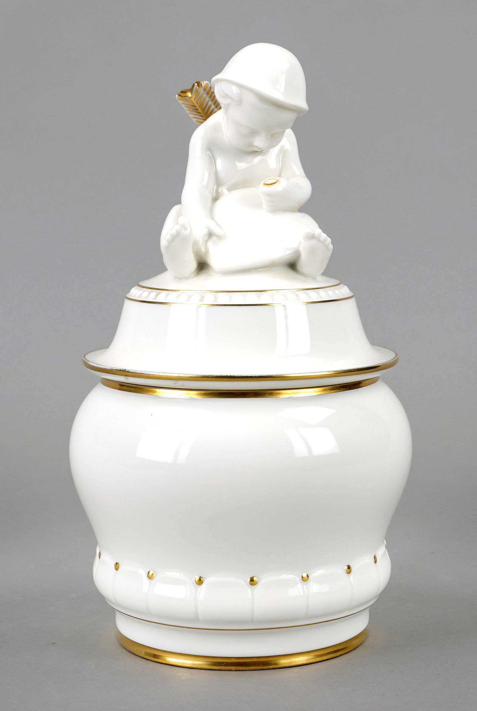 Art Deco cookie tin, Hutschenreuther,: Art Deco cookie tin, Hutschenreuther, Selb, Department of Art 1920-38, designed by Prof. Fritz Klee, model no. 507, bulbous form, seated putto on the lid, piercing a heart with an arrow, the lid chipp