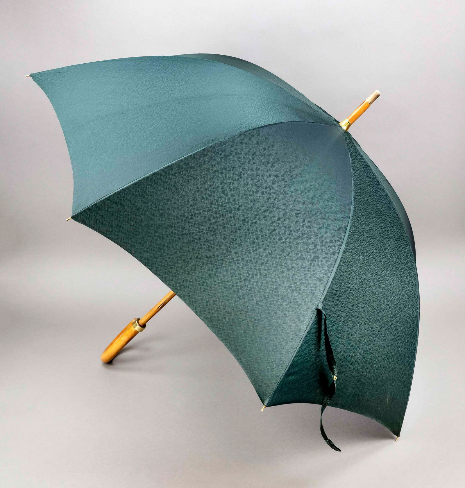 Louis Vuitton, vintage stick umbrella,: Louis Vuitton, vintage stick umbrella, light-colored wood with gold-colored hardware and covering of fir-green discreetly patterned fabric, curved handle with metal cuff and logo lettering, locking st