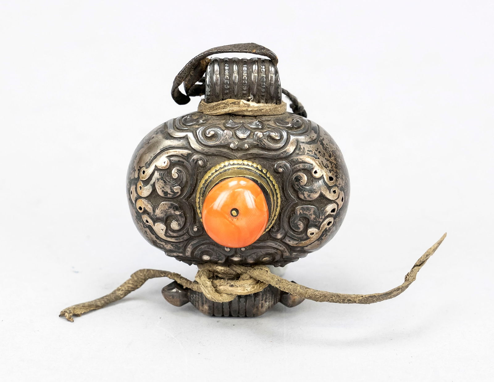 Small gau, Tibet 19th century, partial: Small gau, Tibet 19th century, partially silver-plated copper. Leather lacing, large red coral, slightly rubbed, d. 6 cm