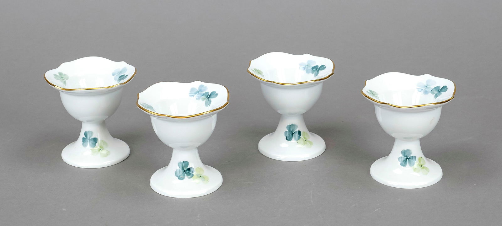 Four egg cups, Meissen, 21st cent: Four egg cups, Meissen, 21st century, 2nd choice, shape Wellenspiel Pur, design Sabine Wachs, decoration clover, gold rim, h. 7 cm