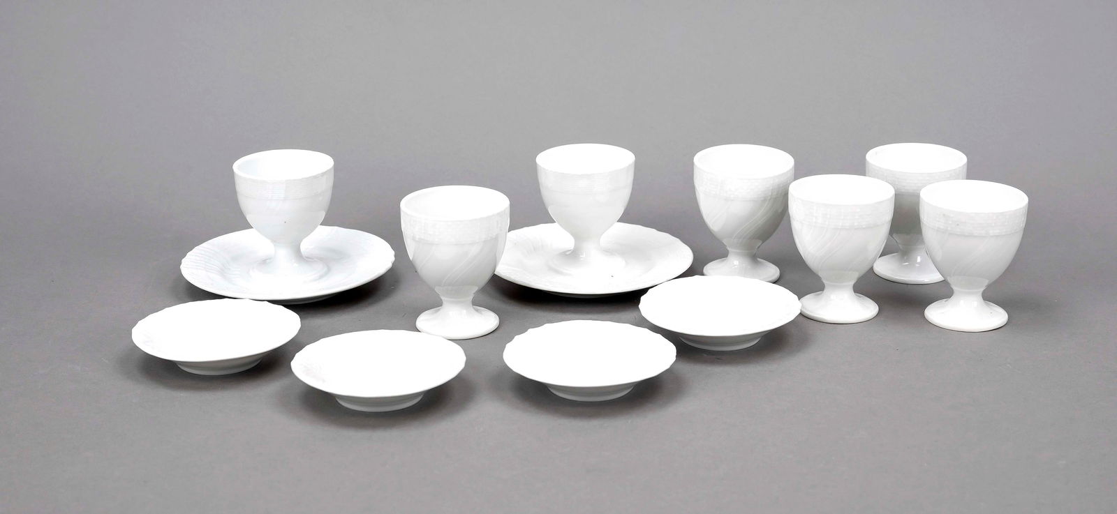 Mixed lot of 11 pieces, KPM Berli: Mixed lot of 11 pieces, KPM Berlin, marks 1945-92, 1st and 2nd choice, Neuosier form, white, 7 egg cups, 2 of which on a fixed stand, h. 6 cm, 4 confectionery plates, Ø 7.5 cm