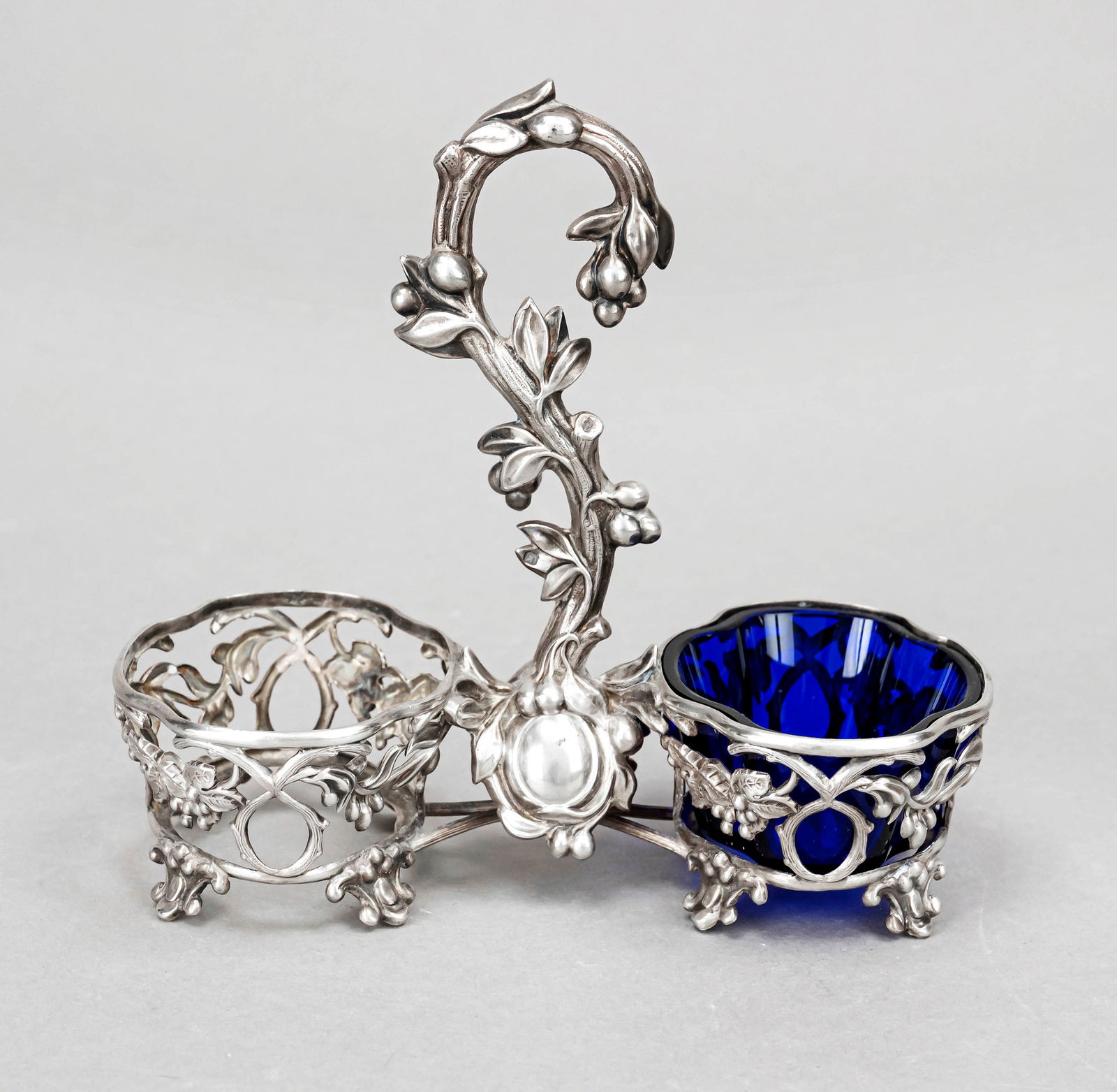 A condiment bowl, French, mark 19: A condiment bowl, French, mark 1911-16, maker's mark Alphonse Debain, Paris, silver 950/000, 2 curved oval bowls joined by a decorated central handle, richly pierced walls, floral relief decoration, o