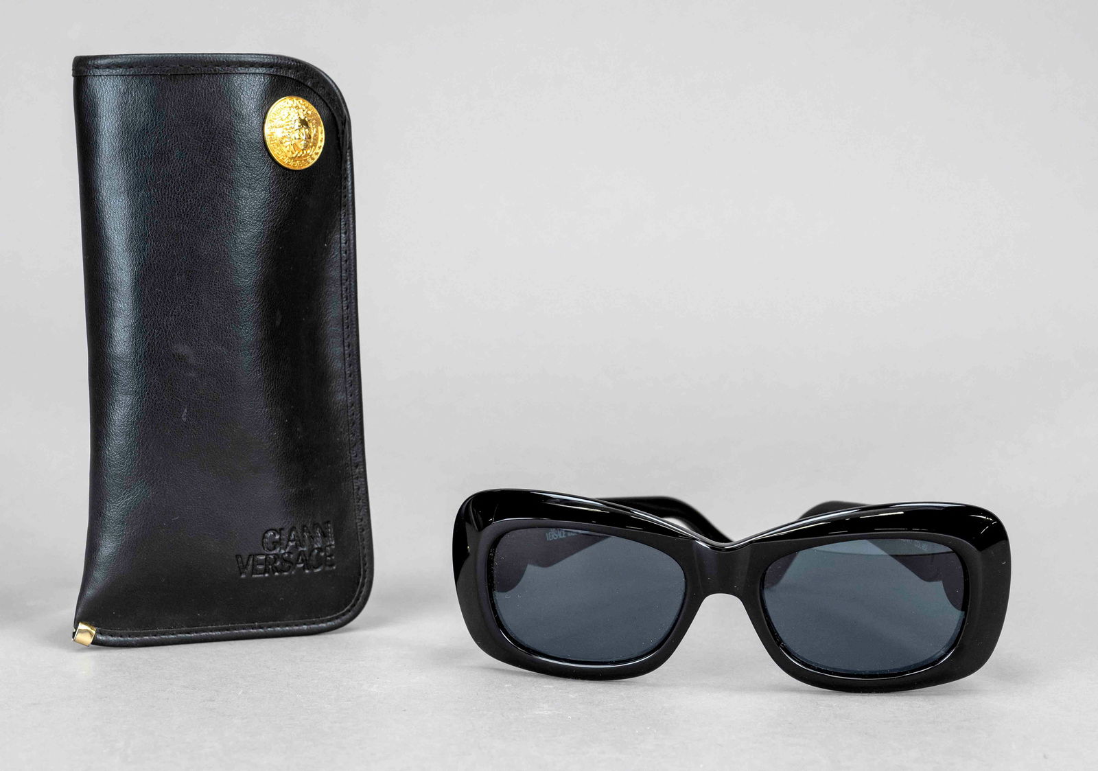 Gianni Versace, sunglasses, wide: Gianni Versace, sunglasses, wide black plastic frame with wide temples and large gold-coloured logo applications, anthracite tinted lenses, incl. original case, slight signs of wear, case approx. 7.5