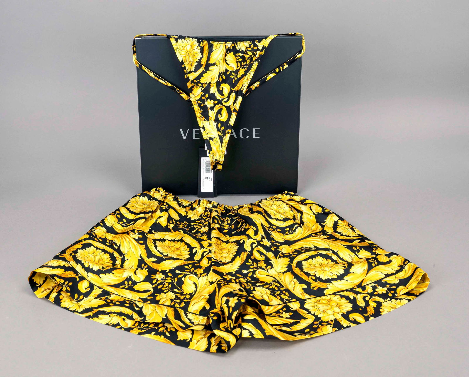 Gianni Versace, thong and pyjama: Gianni Versace, thong and pyjama shorts, both made of 100% silk in black with all-over baroque print, shorts with loose cut and elasticated cuffs, incl. original labels and OK, unworn, size 3