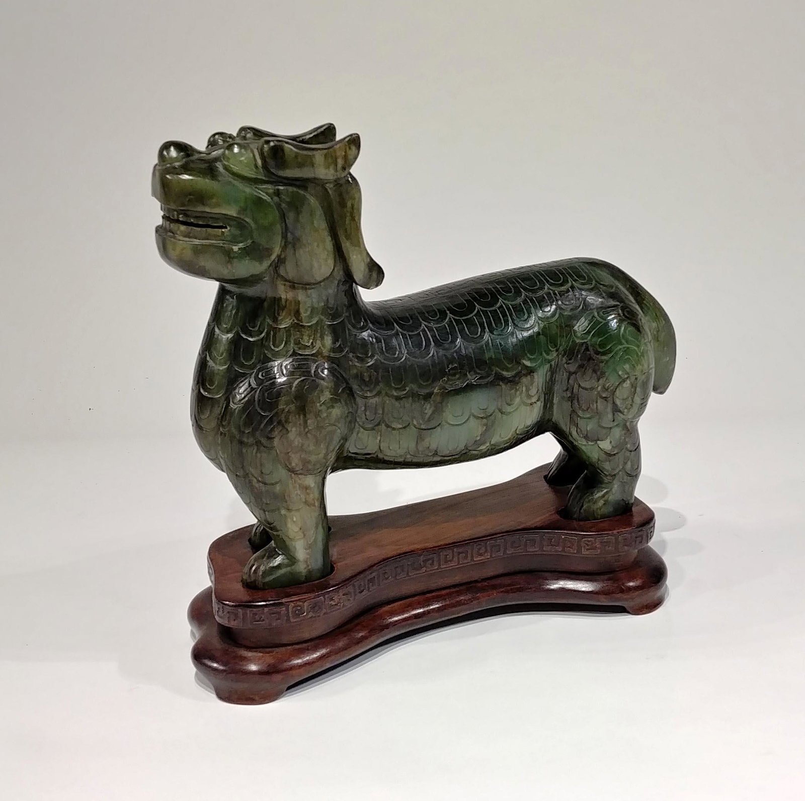 A Large Chinese Spinach Green Jade Lion. NO RESERVE!: A large Chinese carved jade lion with custom stand and box. Dark green spinach jade. Height: 8 7/8 x Length: 11 1/2 inches. NO RESERVE!