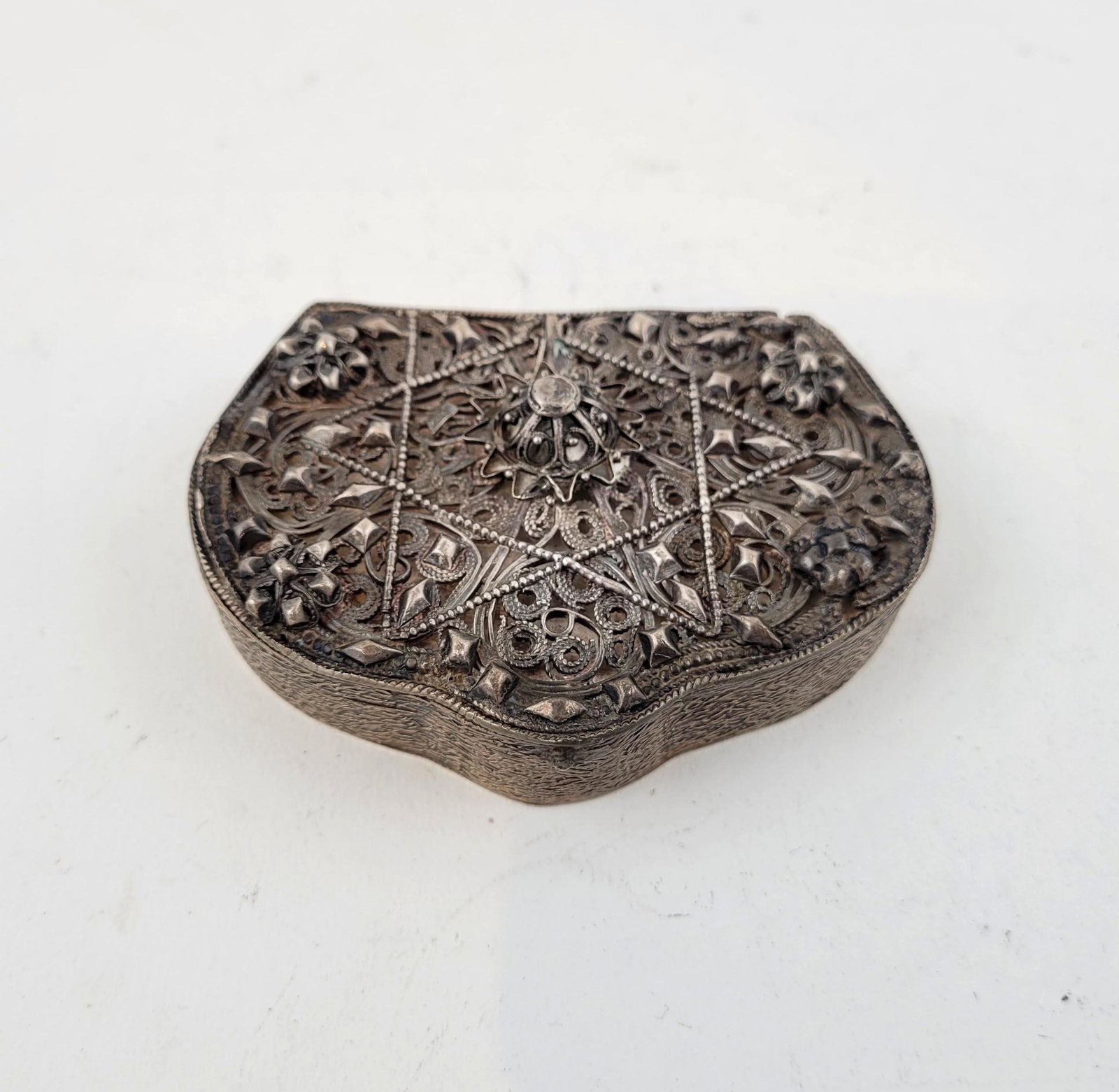 A Yemenite Filigree Silver Box: A fine Yemenite silver box with filigree and hand incised worked sides. 3 1/4 x 2 1/4 inches. Property from the estate of Dr. Nafis Sadik, no reserve.