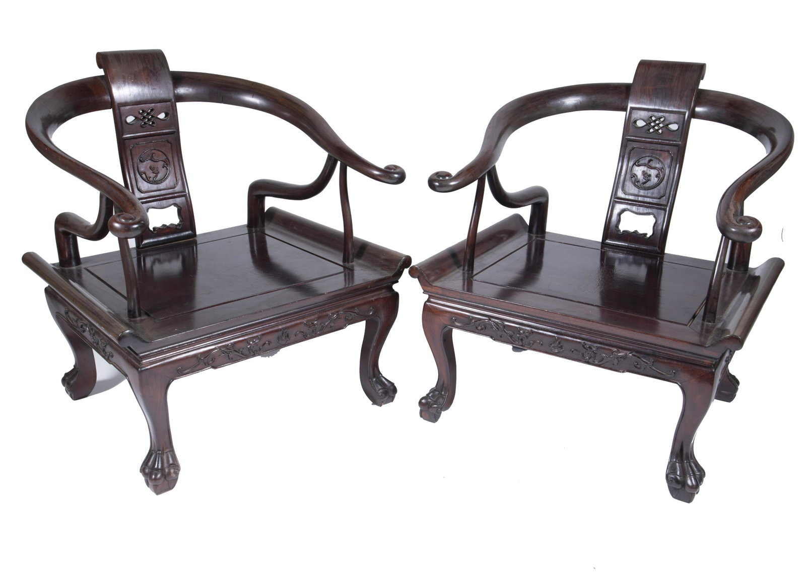 Pair of Chinese Hardware Chairs: A pair of wooden chairs with feline legs. Decorative designs are distinguished on exterior of surface. Stylized beams support arm rests. Early 20th century. 29 in. H x 21 1/4 in. W