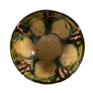 Bamiyan Ceramic Glaze Pottery Bowl: A Bamiyan ceramic glaze pottery bowl with lotus motif. Around the cavetto of the bowl are hues of green and yellow with stylized decoration between each petal. Wear is due to commencement of age. 5 in