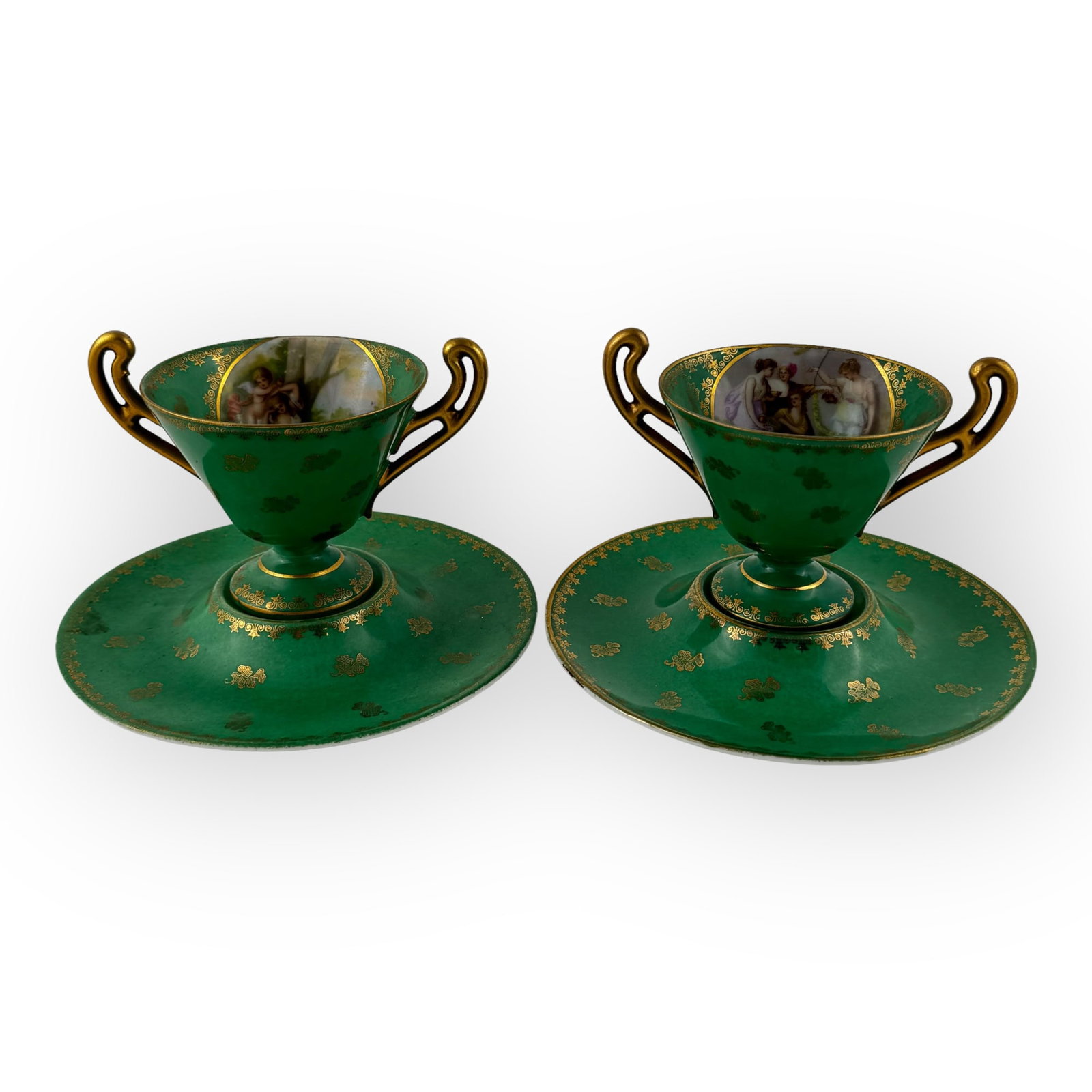 Pair of Royal Vienna Cup and Saucers: Pair of Royal Vienna cup and saucers. The cup measures 3.75 x 5 x 3.5 inches and the saucers have a diameter of 6.4 inches.