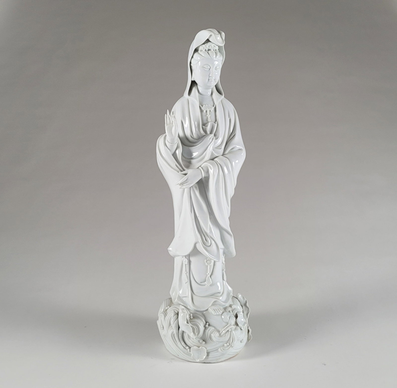 Chinese Blanc de Chine Statue of Quan Yin: Chinese Blanc de Chine statue of Quan Yin. Quan Yin poses with a traditional hand sign on a base of lotuses with pond water details. Bottom of base and tip of finger are broken. Dimensions: 18 1/2 x 5
