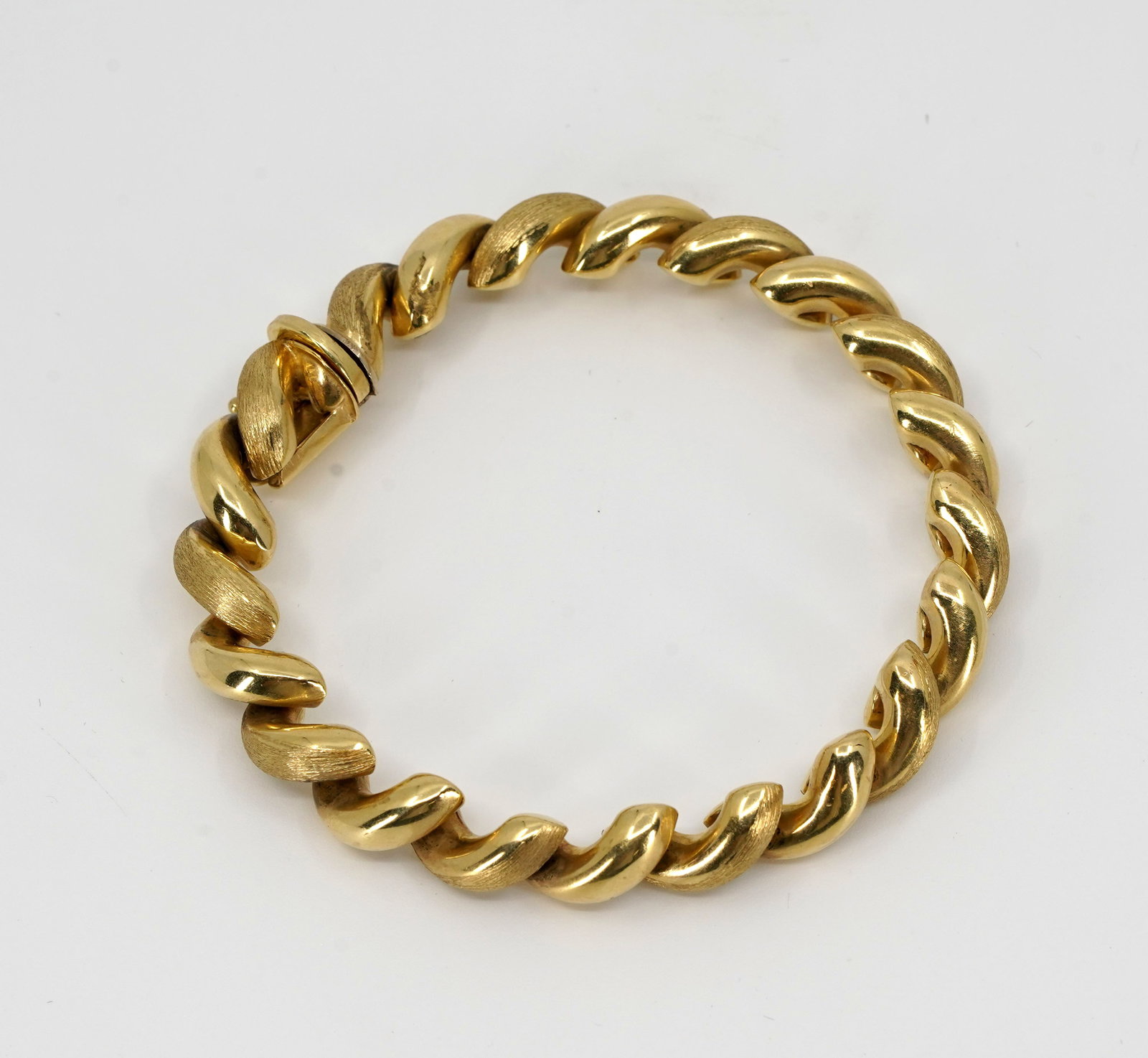Italian 14 kt Gold San Marco Bracelet: Italian gold San Marco bracelet. The chain is composed from polished and matte gold half-ribs interlocking in an alternating pattern. The bracelet is secured with a box clasp and a Figure 8 safety loo