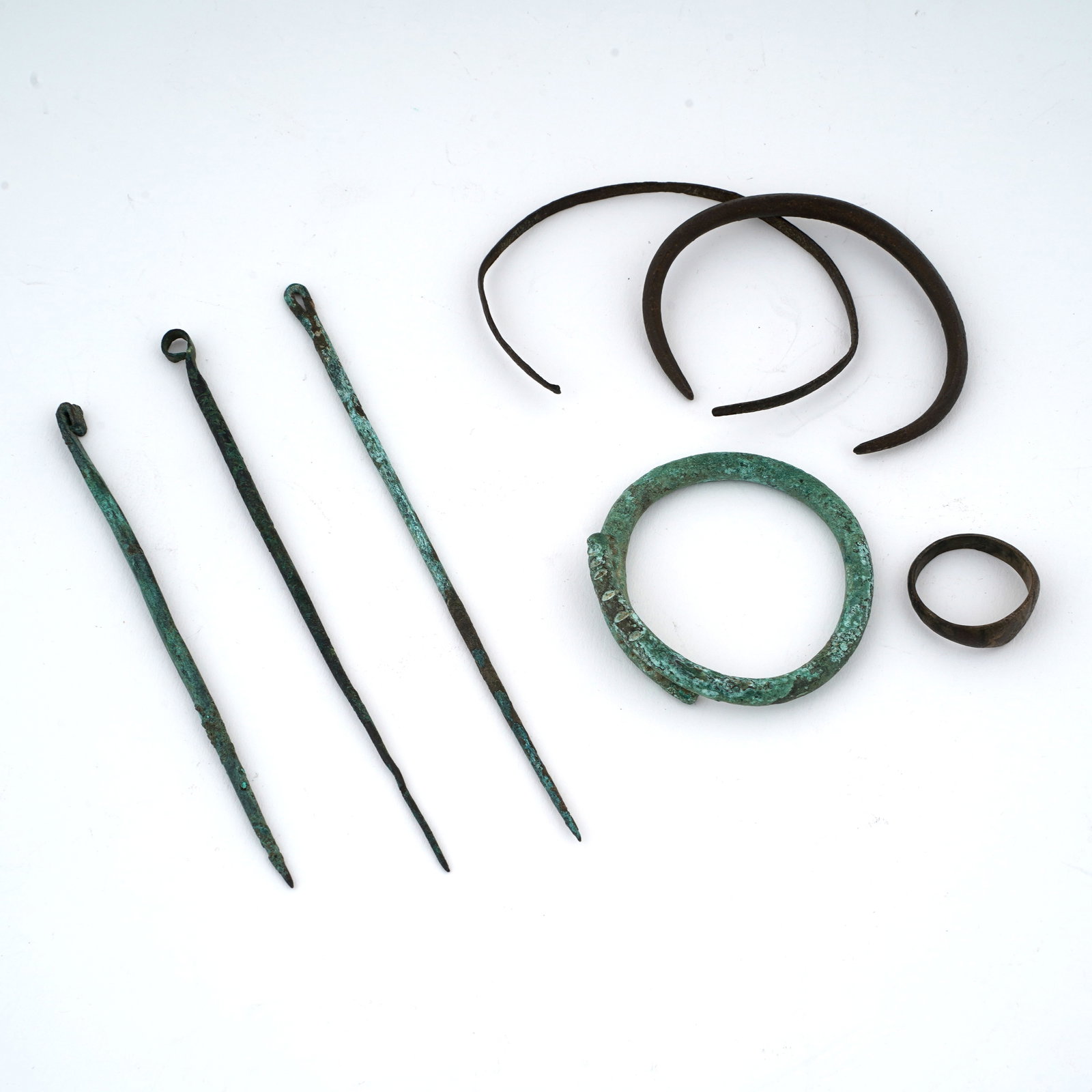 Mixed Lot of Roman & Byzantine Bronze Pieces: Mixed lot of Roman and Byzantine bronze pieces. The lot contains Roman fibulae/needles and coil and Byzantine jewelry. Dimensions: 5 1/4 inches (one fibulae/needle).