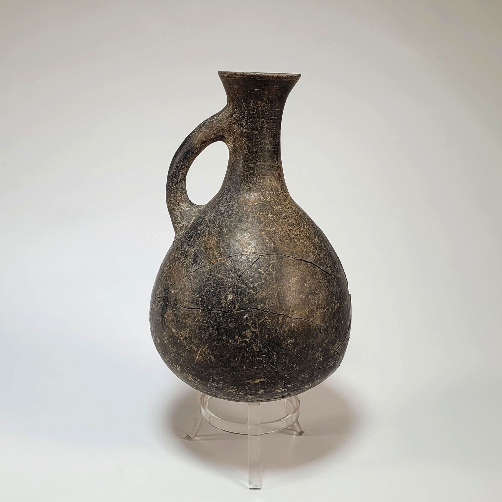Early Iranian Blackware Pottery Bulbous Ewer with Handle: Early Iranian blackware pottery bulbous ewer with handle. The ewer has a loop handle attaching the long, tapered neck to the body. Circa 1500 - 1000 BCE. Dimensions: 9 inches (height).Provenance: Acqu