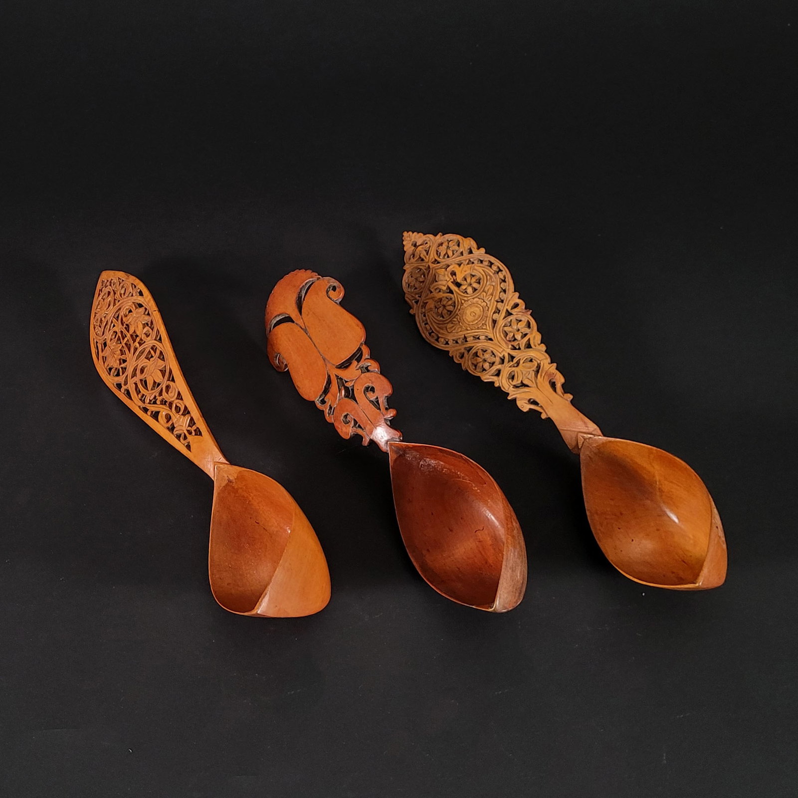 Lot of Three Qajar Persian Fruitwood Decorative Spoons: Lot of three Qajar Persian fruitwood decorative spoons. Two of the spoons have intricate floral openwork designs on the handles while the third has boteh carvings on its handle. One of the floral spoo