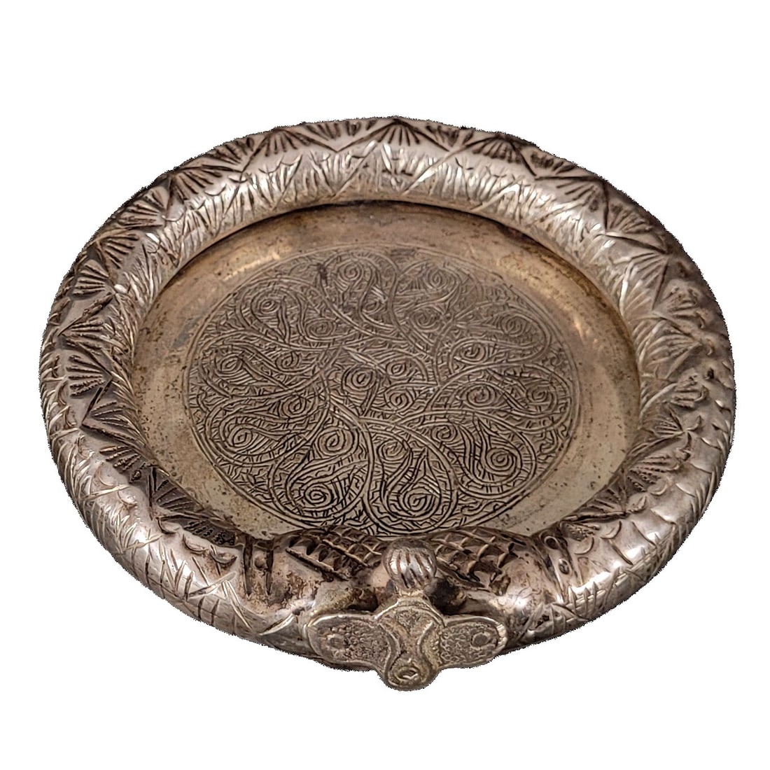 Egyptian Silver Engraved/Etched Ashtray, No Reserve: Egyptian silver engraved/etched ashtray. The tray appears to be a marriage between an ornamental bracelet and a silver plaque. The snake-like rim has engraved geometric and leaf patterns while the fac