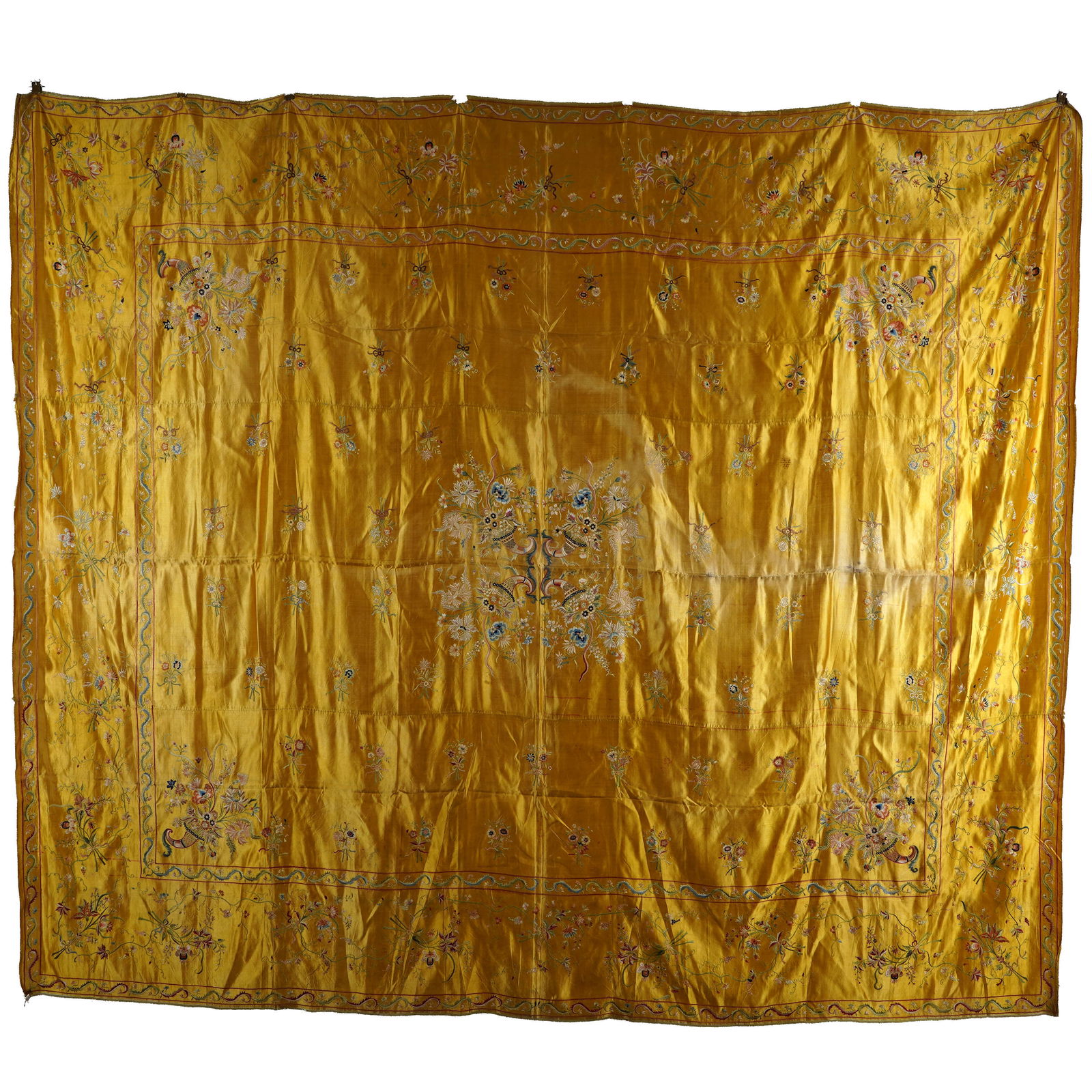 Chinese Silk Embroidered Bed Cover: Chinese silk embroidered bed cover. The bed cover has a luminous yellow grounding and a consistent theme of silk embroidered posy bouquets across its design. The textile is centered by four flowering
