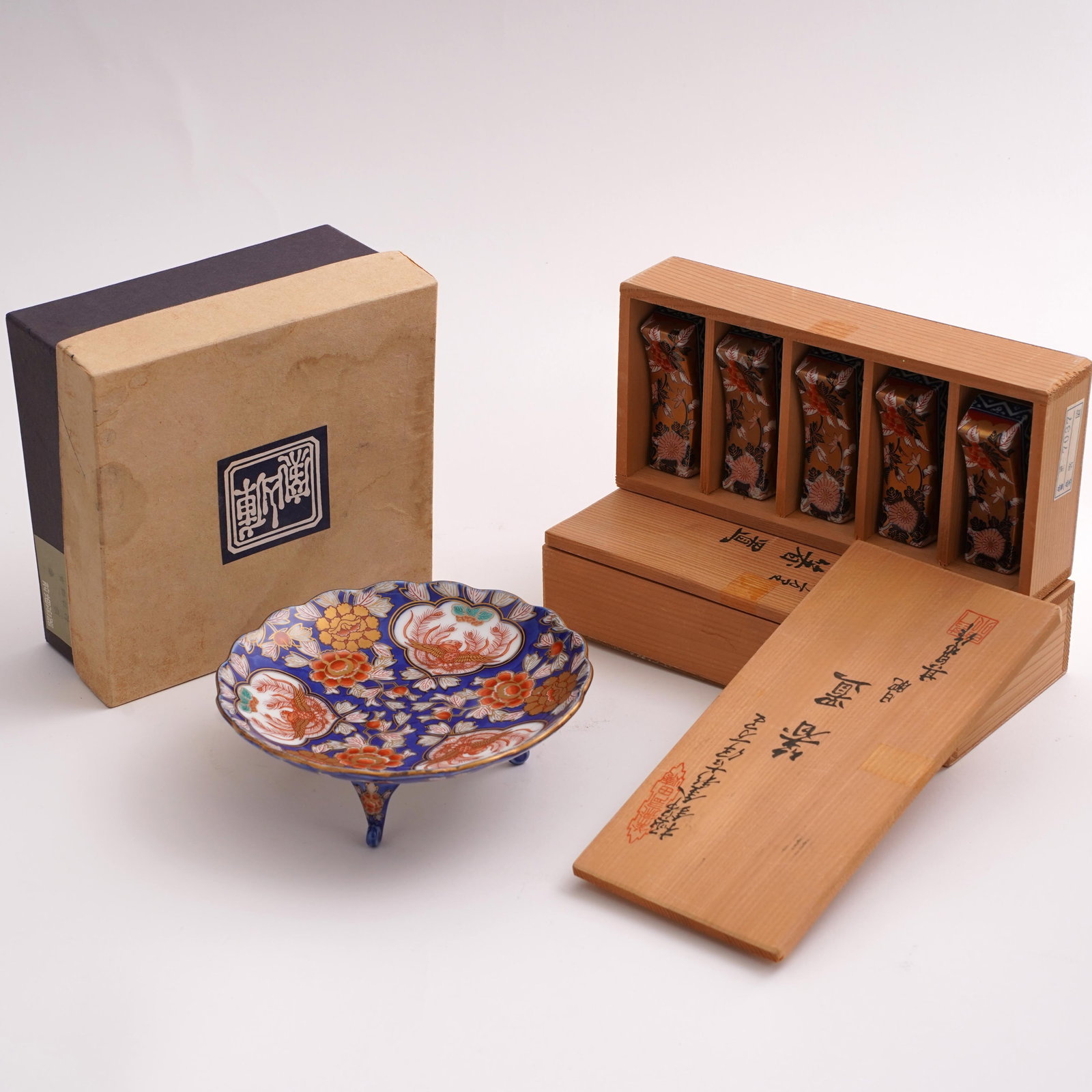 Japanese Porcelain Table Articles with Fitted Boxes: A Japanese lot comprising a small Imari porcelain footed dish, decorated in cobalt blue, iron red, gilt, and polychrome enamels with floral reserves, marked to underside; together with two boxed sets 