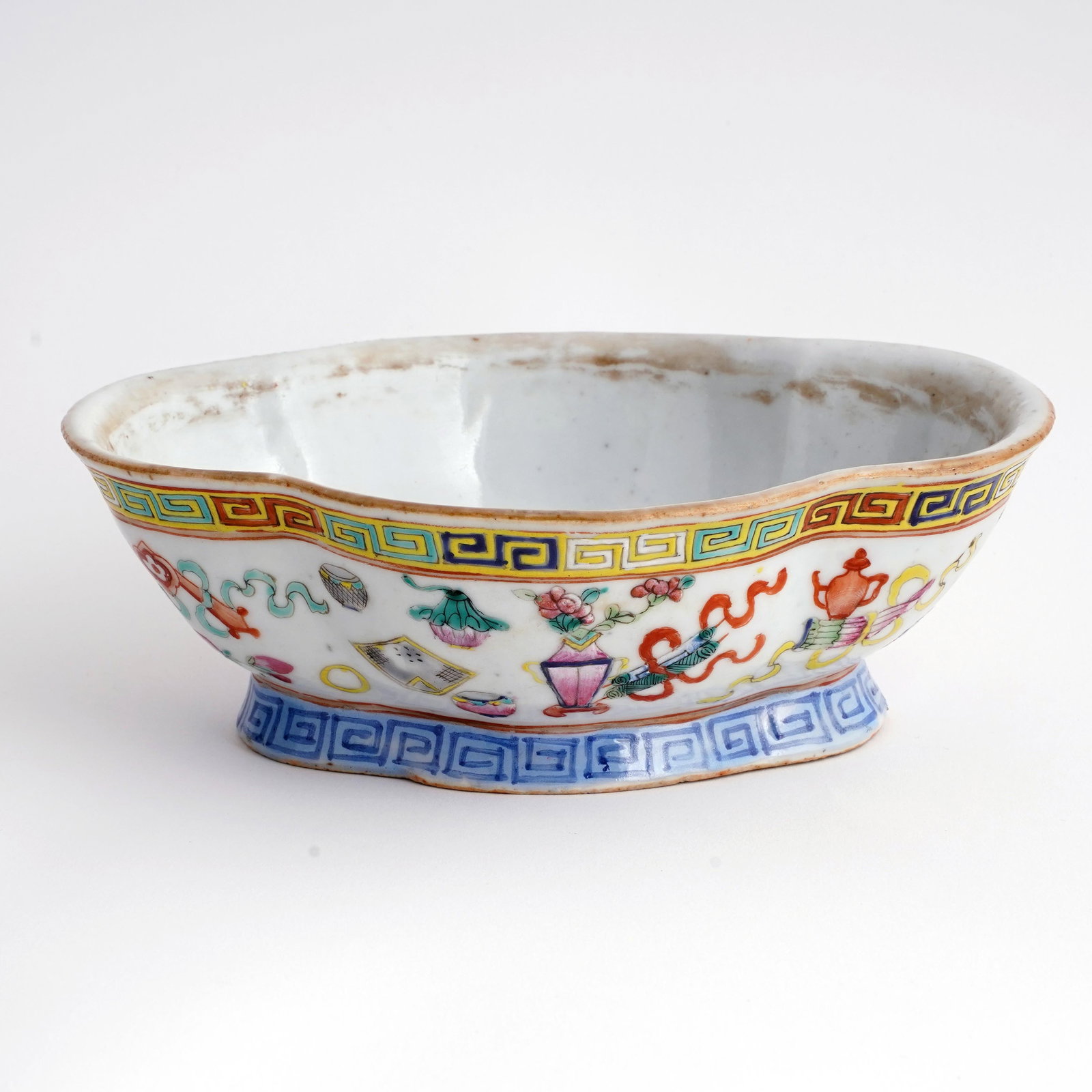 Chinese Famille Rose Porcelain Oval Bowl: Chinese famille rose porcelain oval bowl, decorated with Hundred Antiques motifs and polychrome Greek-key borders, underside with iron-red apocryphal Qianlong seal mark. H: 2 1/2 x L:7 5/8 x W: 5 5/8 