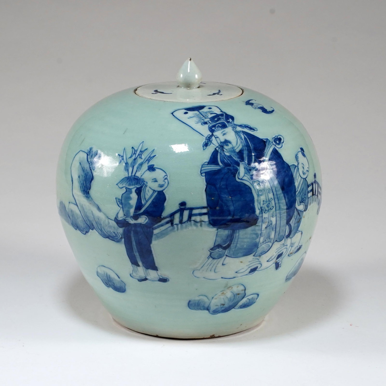 Chinese Porcelain Celadon & Blue Covered Jar: Chinese celadon and blue porcelain covered jar, ovoid form, decorated with robed figure and attendants in landscape, with domed cover and pointed knop. H:10 x D: 10 in.