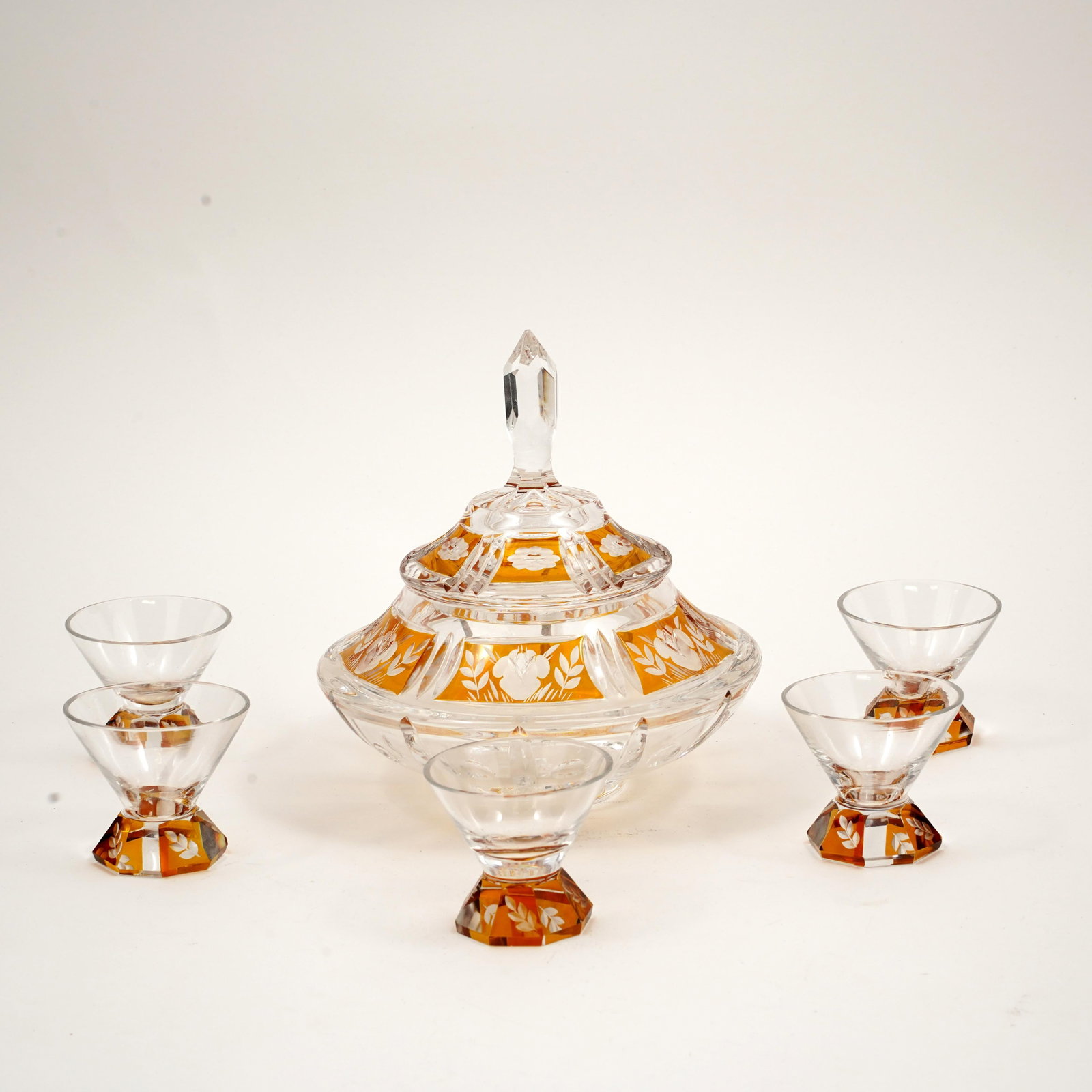 Czech Bohemian Cut Glass Dessert Service: Czech Bohemian cut and engraved glass dessert service with amber-stained panels and white floral decoration, comprising two covered dishes and five footed dessert cups. The larger covered dish with fa