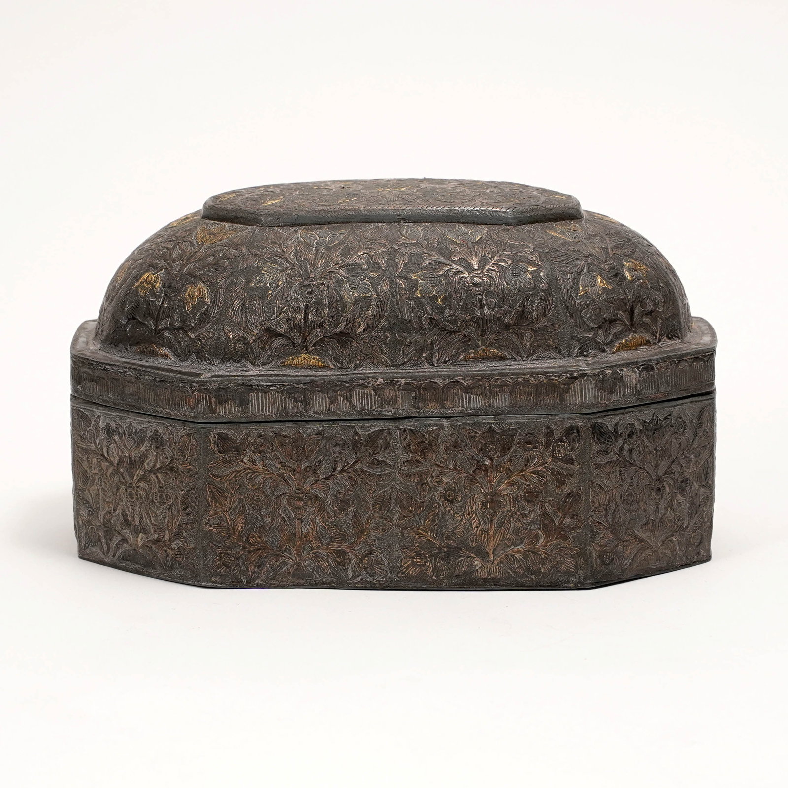 Persian Qajar Gilt Metal Box: Persian Qajar gilt metal box, 19th century, of elongated octagonal form with fitted domed cover, finely worked overall with dense floral and foliate arabesque decoration on a dark patinated ground,