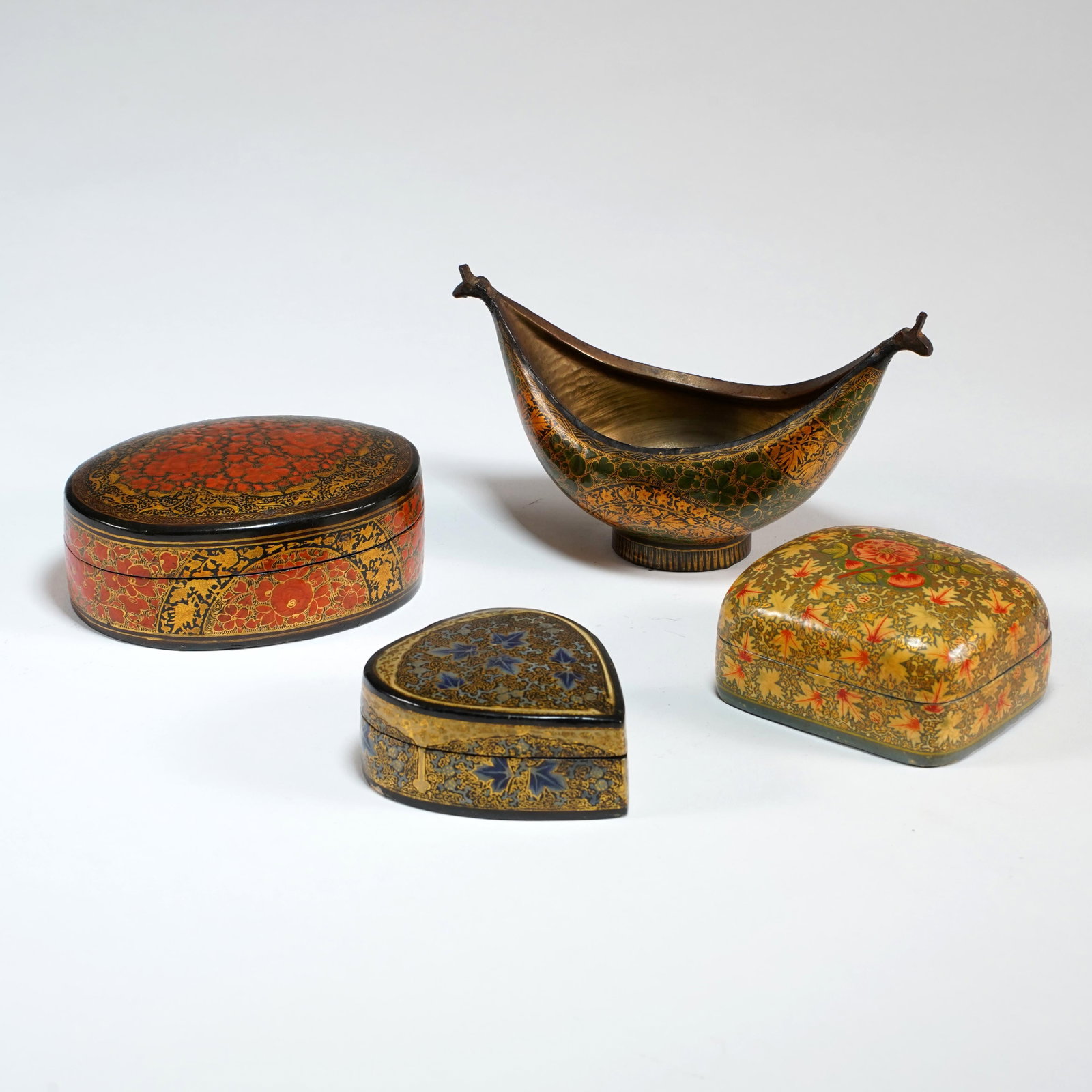 Group of Kashmiri Painted Papier-Mâché Boxes and Kashkul: Group of four Kashmiri-style painted papier-mâché articles, comprising three lidded floral boxes and a kashkul formed bowl, decorated with polychrome floral designs and gilt accents.: L: 6 1/2 x H: