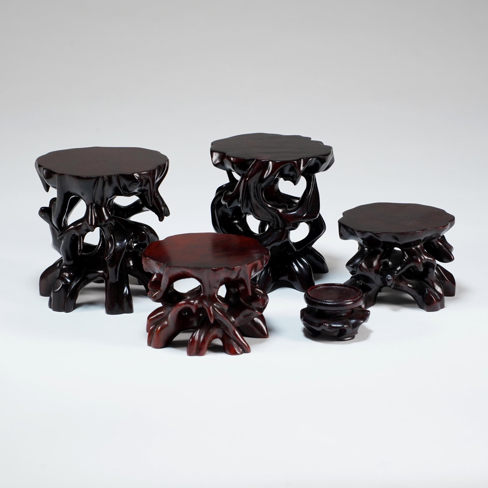 Group of Chinese Hardwood Display Stands: Group of five Chinese carved hardwood display stands, each in naturalistic rootwood style with shaped tops, openwork bases, and dark lacquered finish. Size for big: H: 4 x L: 4 3/4 x W: 3 5/8 in.,