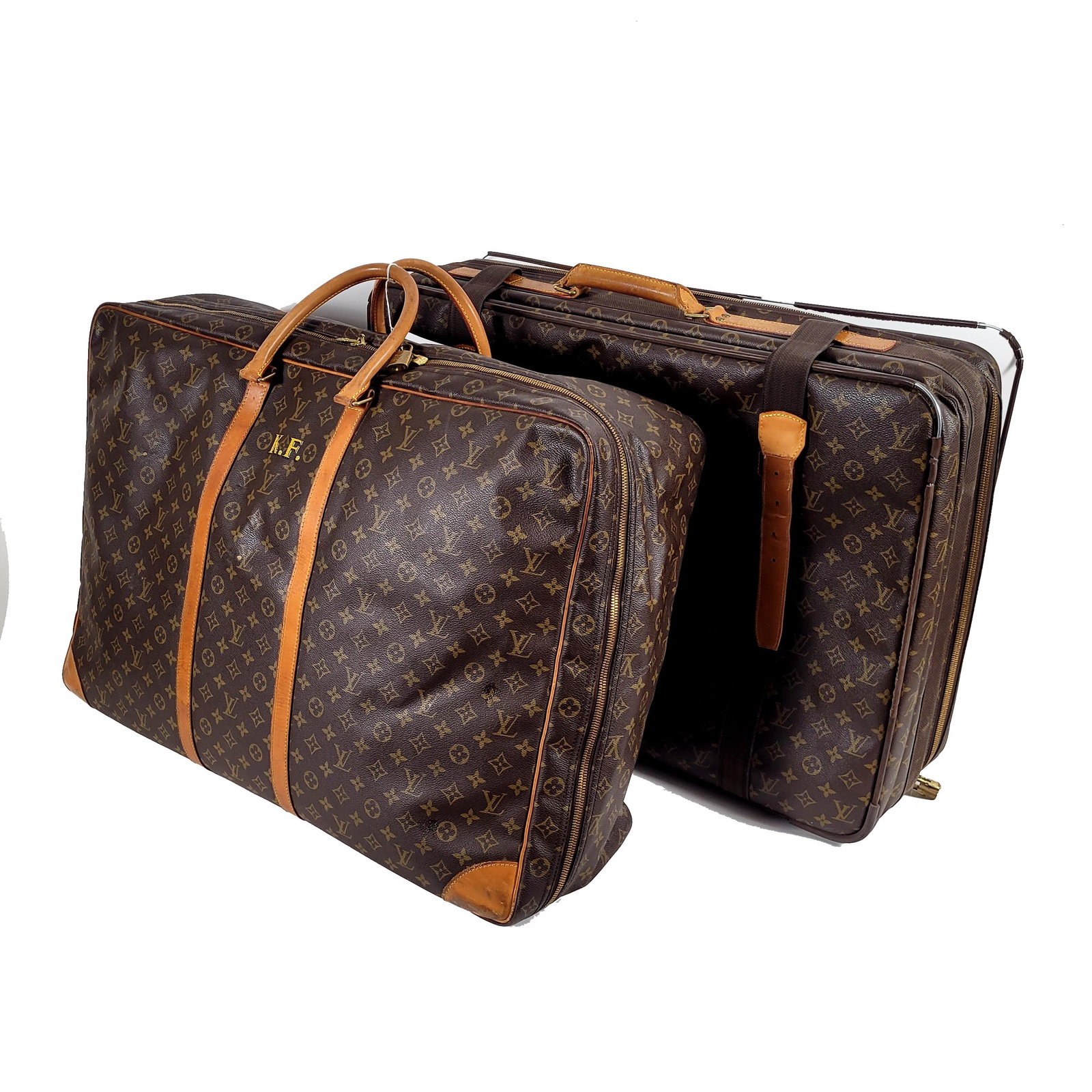 Two Louis Vuitton Monogram Canvas Garment / Travel Bags: Two Louis Vuitton monogram canvas garment/travel bags, 20th century, with vachetta leather trim, brass-tone hardware, and zip closures; one monogrammed “K.F.” Together with a second similar Lo