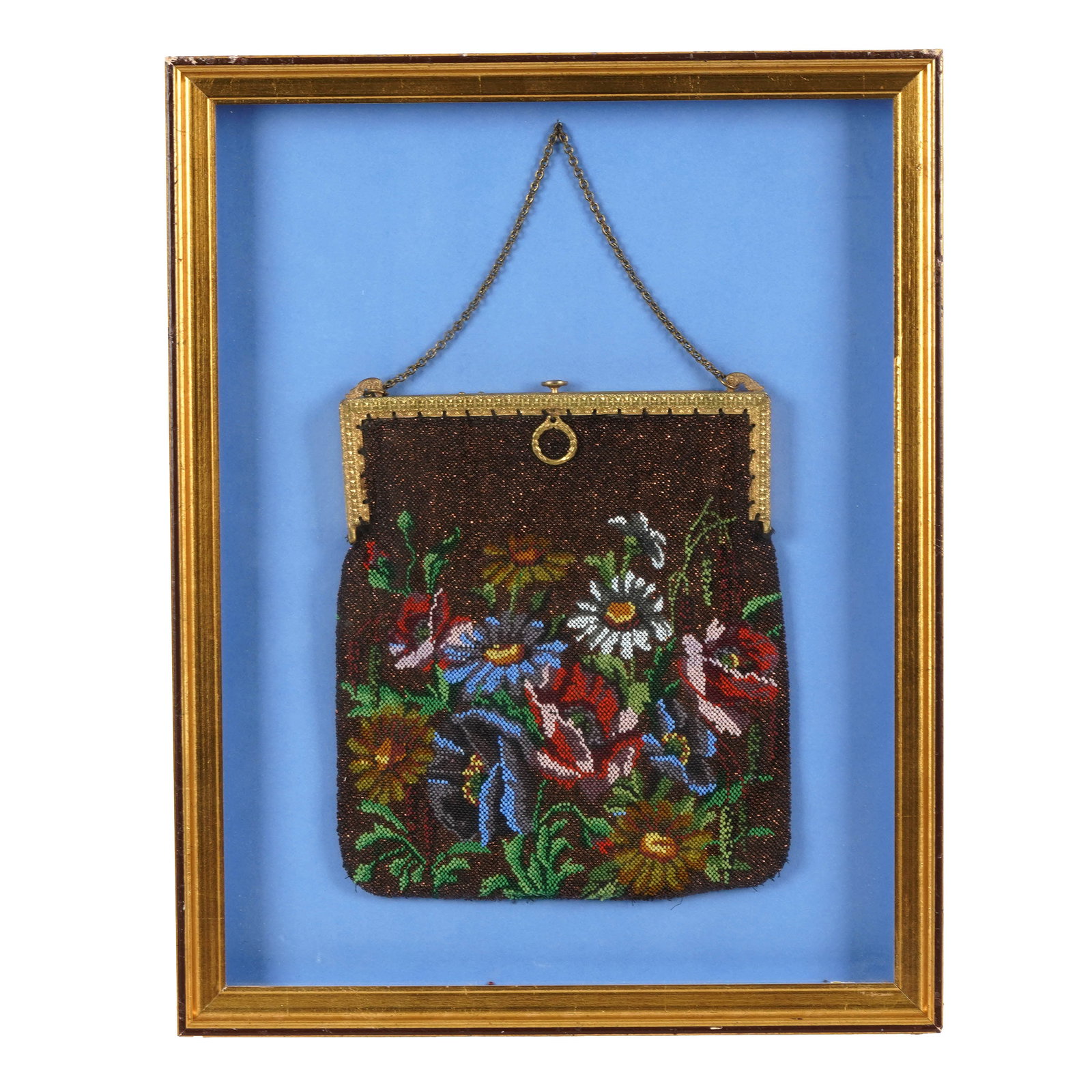 Framed Beaded Evening Bag: Vintage beaded evening bag with dark ground decorated with polychrome floral spray, including red, blue, white, and yellow flowers with green foliage. Mounted as a display piece under glass against a